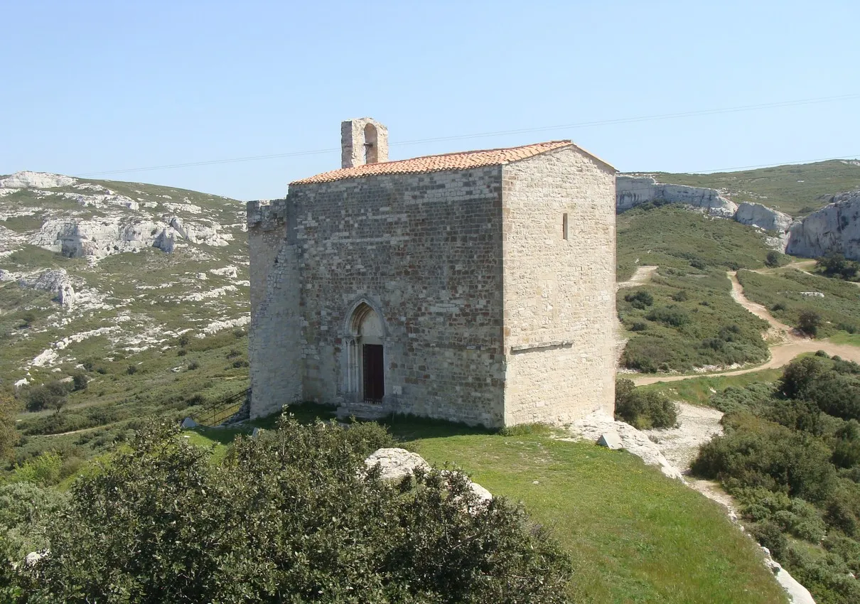 Photo showing: La chapelle de Saint-Michel de Gignac, vue du nord-ouest. Le porche est sur la façade nord, et la face ouest est aveugle. Noter le pan de muraille restant accroché à la chapelle sur la gauche.