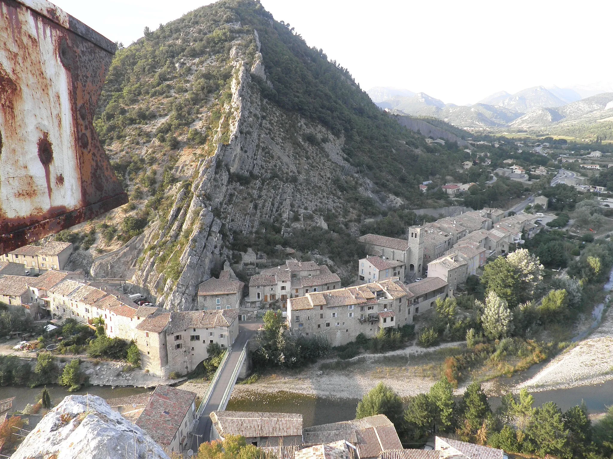 Photo showing: Le drapeau rouillé à gauche est une girouette fixée sur le rocher. Elle a été rénovée et repeinte en drapeau français par les jeunes du village qui ont escaladé le rocher.