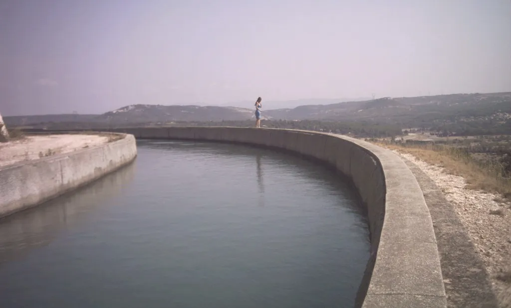 Photo showing: Le canal d Marseille longeant le flanc de la barre de coteaux au nord de Coudoux. Vue vers le sud-est, le long de la route des Quatre Termes (au nord-ouest du village). En arrière-plan à gauche du personnage, les hauteurs de Ventabren. Le fleuve l'Arc passe sur leur côté sud, dans la vallée dont on voit le profil à peu près dans l'axe du personnage.