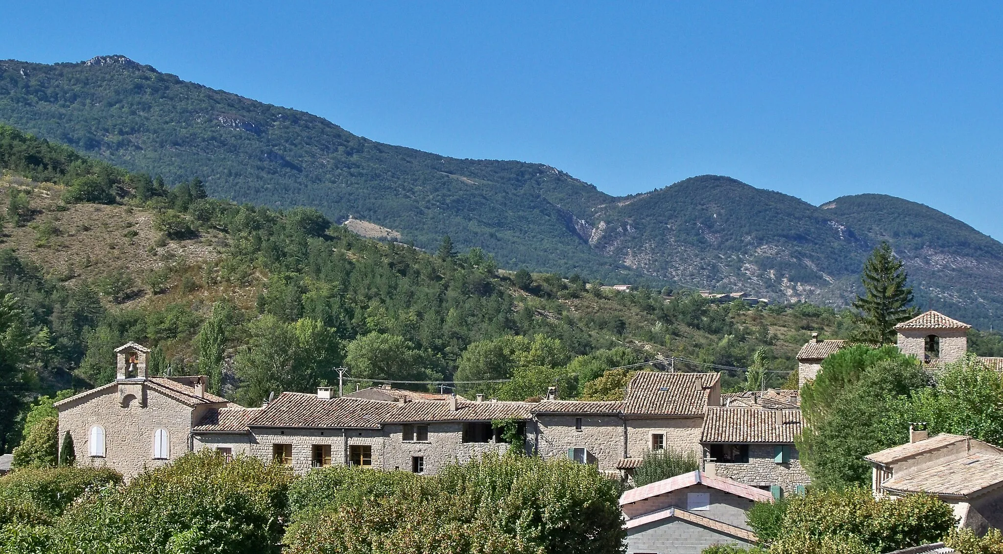 Photo showing: Sainte-Euphémie-sur-Ouvèze (Drôme, France). Vue d'ensemble, avec l'église Sainte-Euphémie à droite et le temple protestant à gauche ; entre les deux, façades sur la rue du Levant.