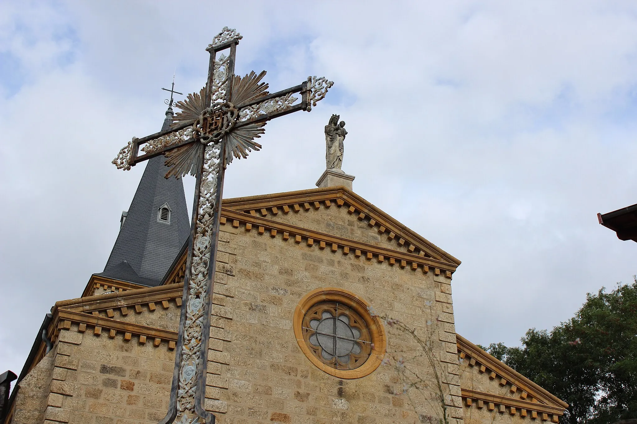Photo showing: Croix en métal et église de Montromant.
