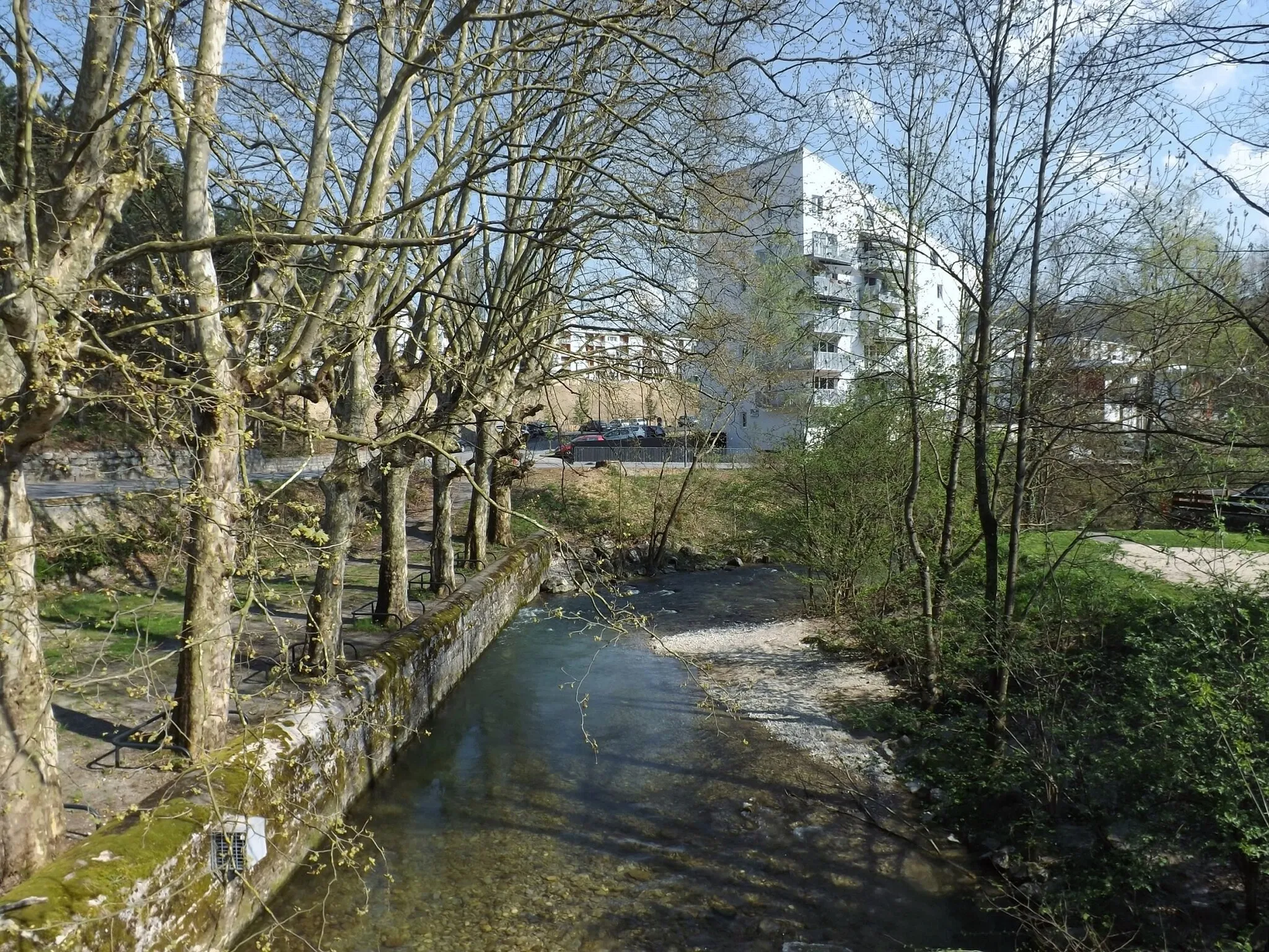 Photo showing: Sight, from the Pont-Vieux, of the Hyères river separating communes of Chambéry (left) and Cognin (right), with a row of trees, felled some months later, in Savoie, France.