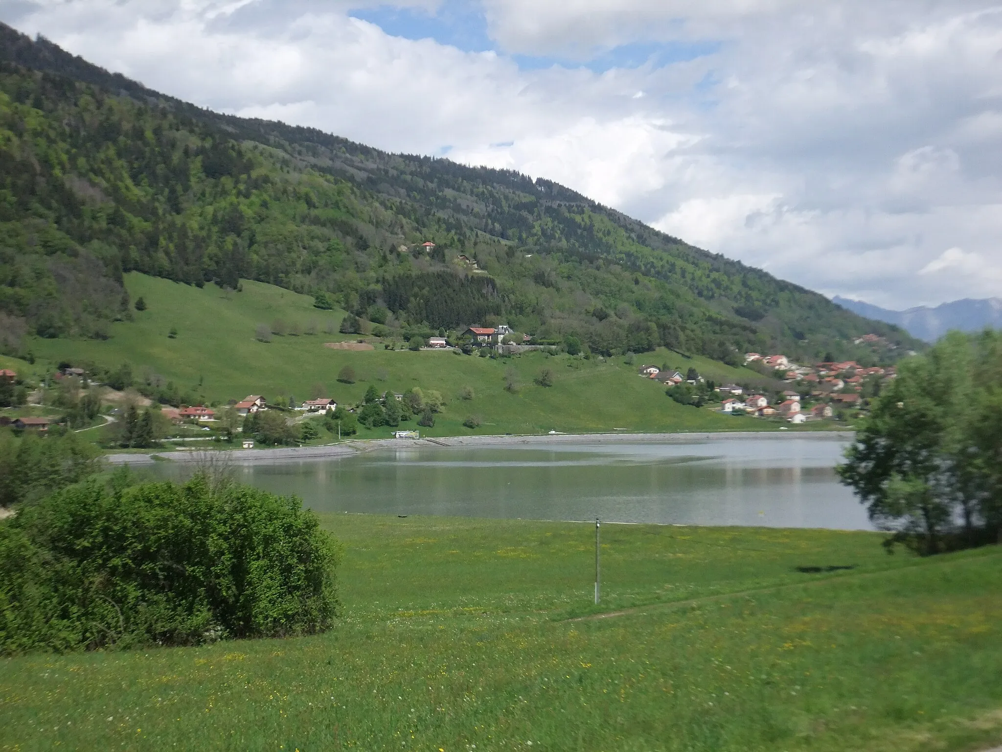 Photo showing: Bassin d'éclusée le long de la conduite EDF Arc-Isère alimentant la centrale hydro-électrique du Cheylas, servant au stockage des eaux arrivant par gravité ou remontées par pompage, construit à l'emplacement d'un ancien marais. Il est vu de Saint-Pierre en direction d'Allevard, avec les maisons des hameaux de La Rochen Le Chaboux, Les Maladières, s'étageant sur l'adret de Bramefarine.