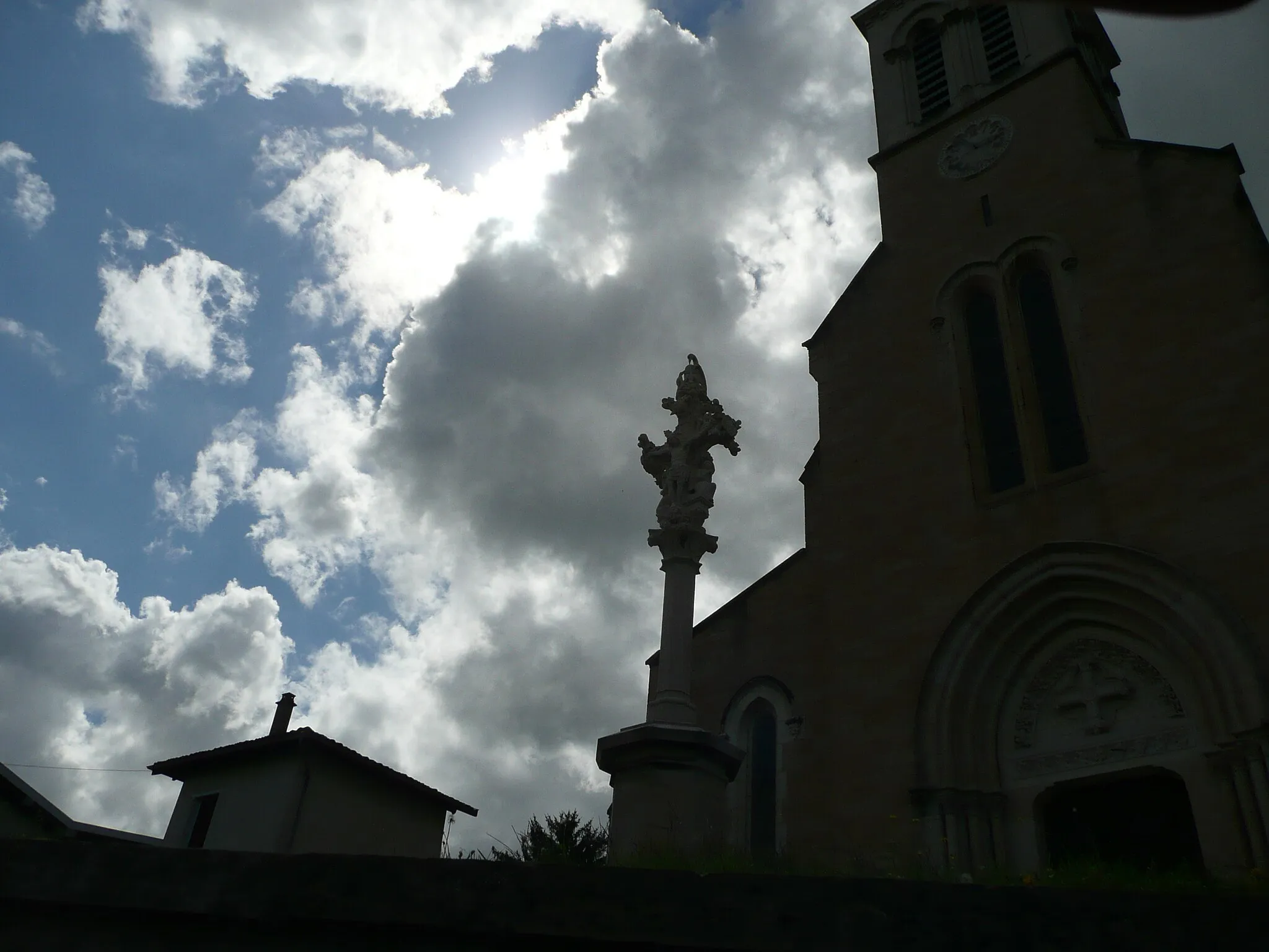 Photo showing: Calvaire (inscrit aux monuments historiques) et église de Mogneneins (France) en silhouette.