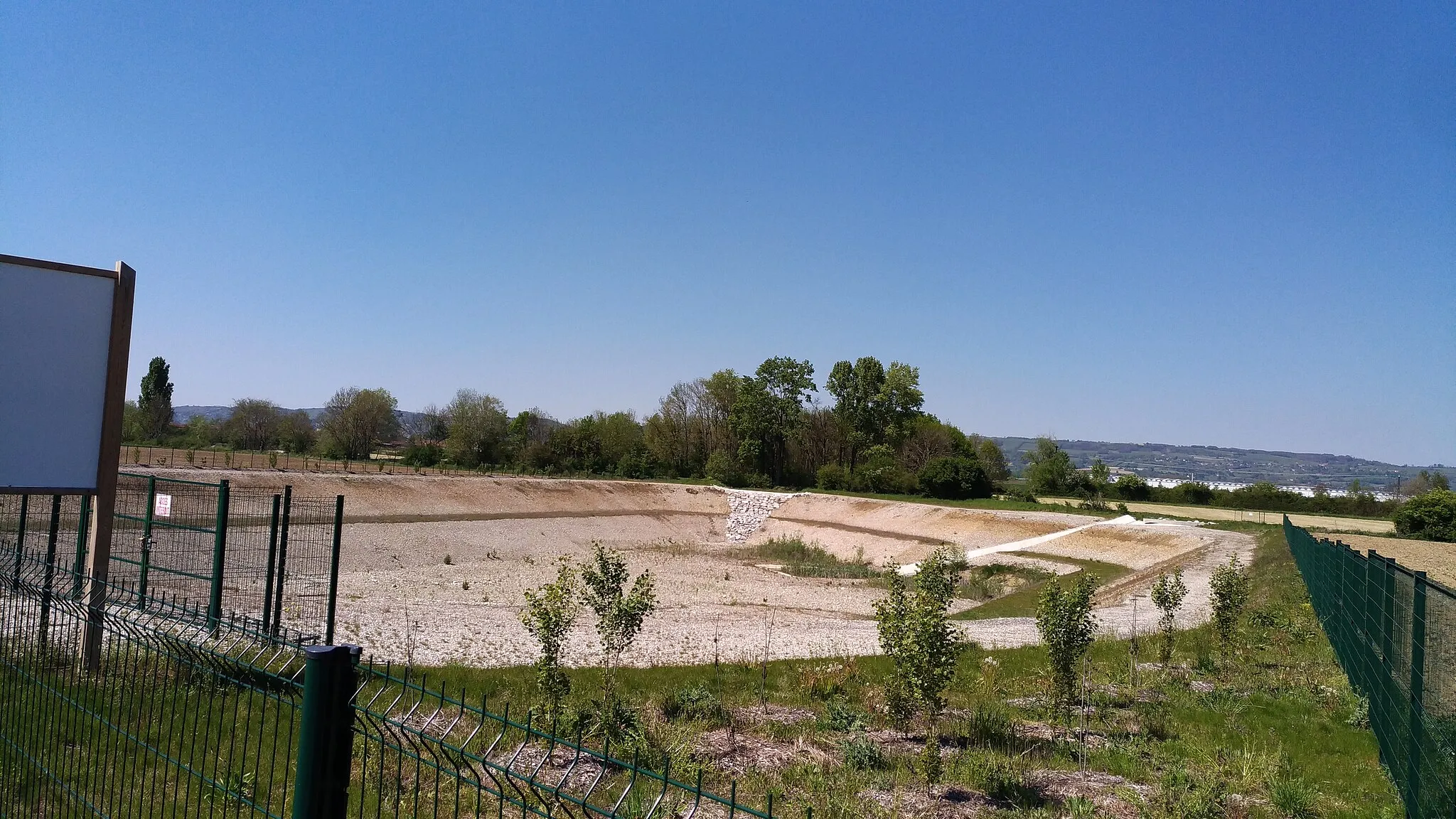 Photo showing: Bassin de détention du Rival, sur la commune de Brézins, en Isère. Capacité de rétention de 63 000 m³, profondeur de 8 m. Se remplit automatiquement lorsque le débit du Rival est supérieur à 12 m³/s. Débit maximal écrêté 10 m³/s.