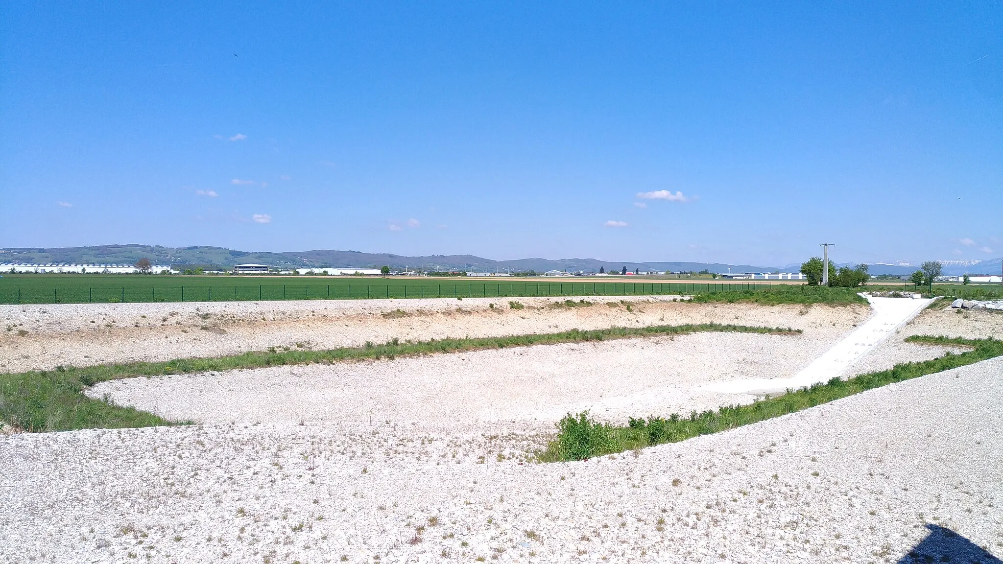 Photo showing: Bassin de détention de la Coule, sur la commune de Brézins, en Isère. Capacité de rétention de 23 000 m³, profondeur de 8 m. Se remplit automatiquement lorsque le débit de la Coule est supérieur à 4 m³/s. Débit maximal écrêté 6 m³/s.