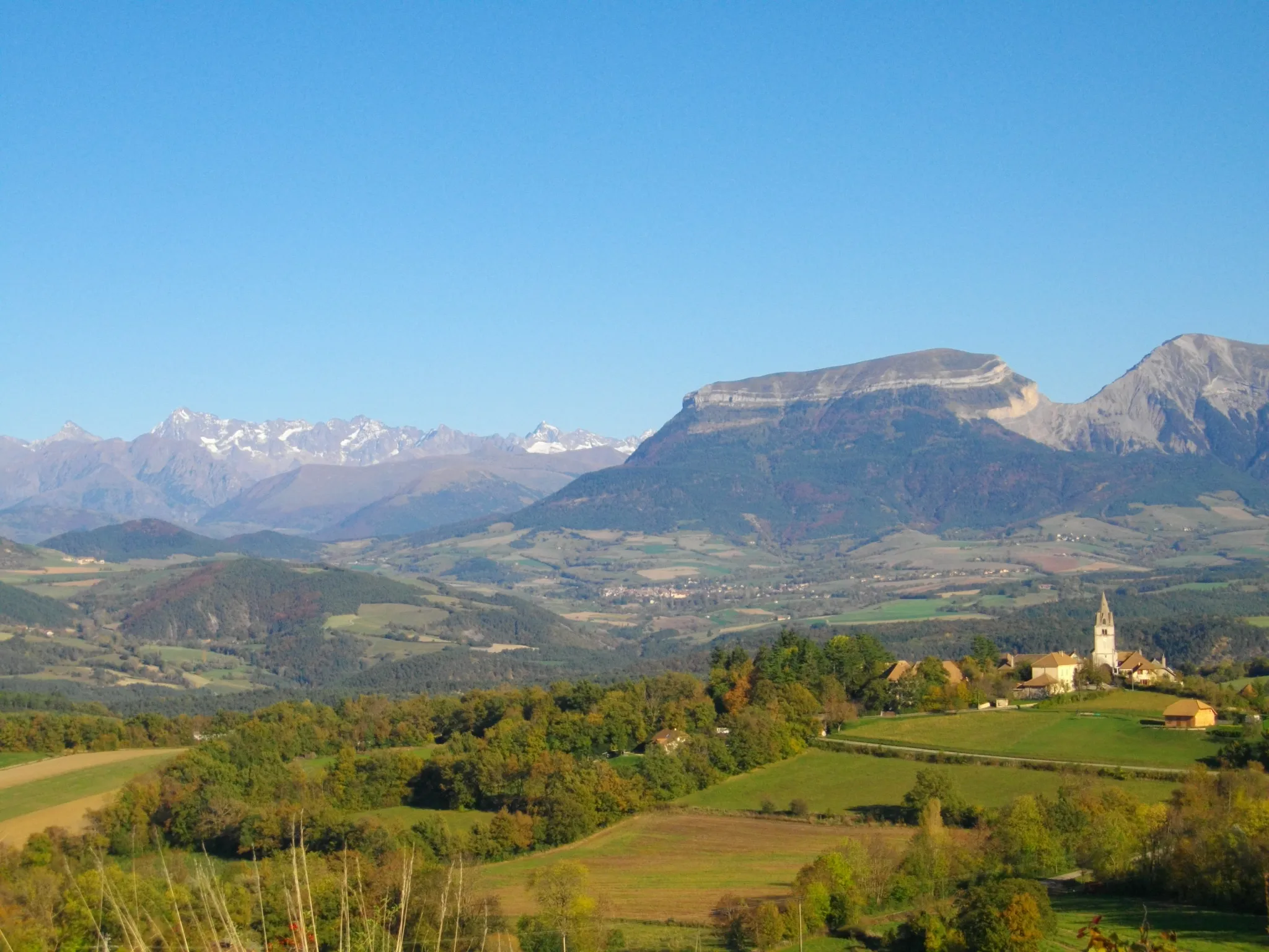 Photo showing: Le clocher de l'église de Clelles, Mens, le Bonnet de Calvin et le Massif des Ecrins.