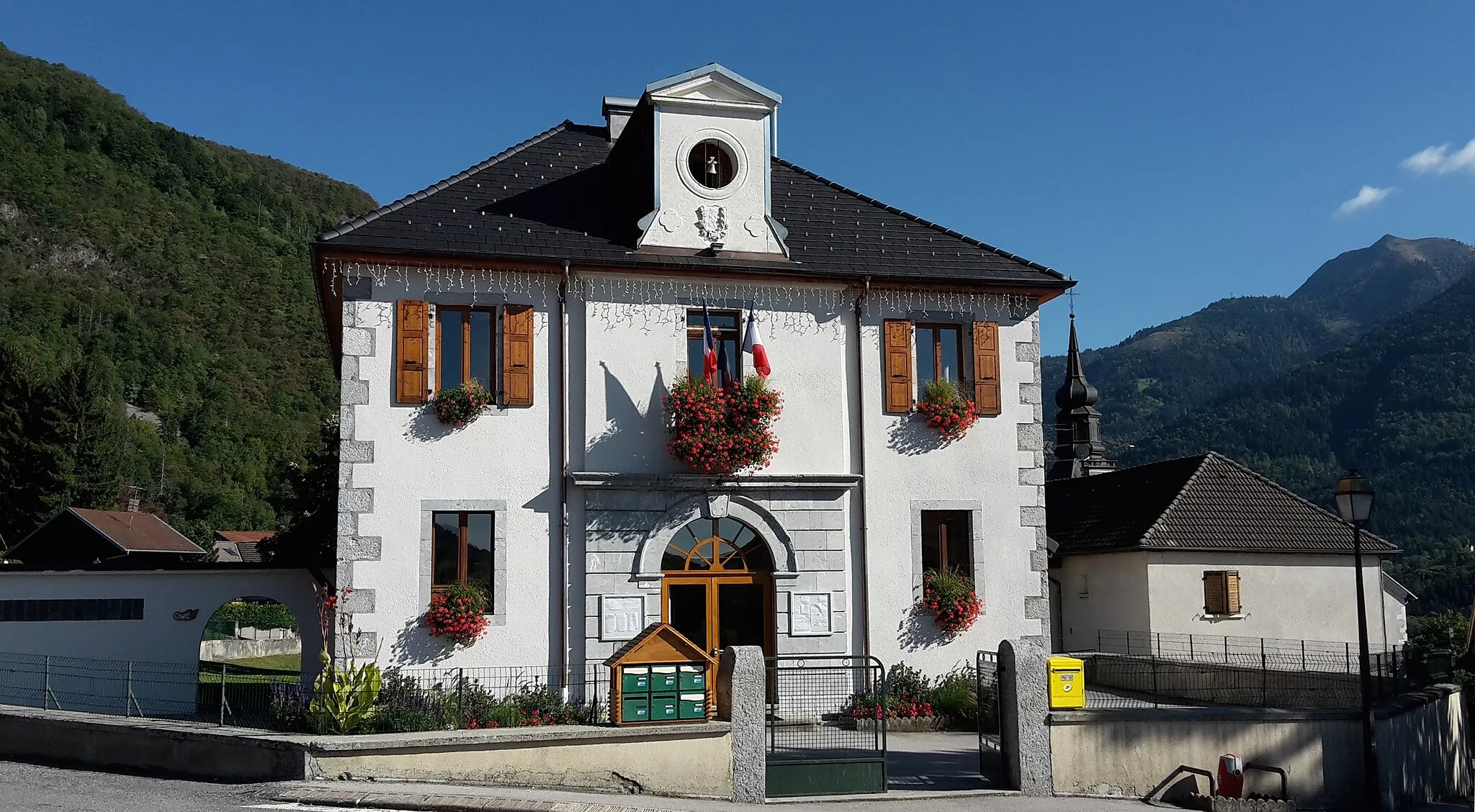 Photo showing: Façade de la mairie de Ville-en-Sallaz en été avec le Môle à droite et le sommet du clocher de l'église de la commune.