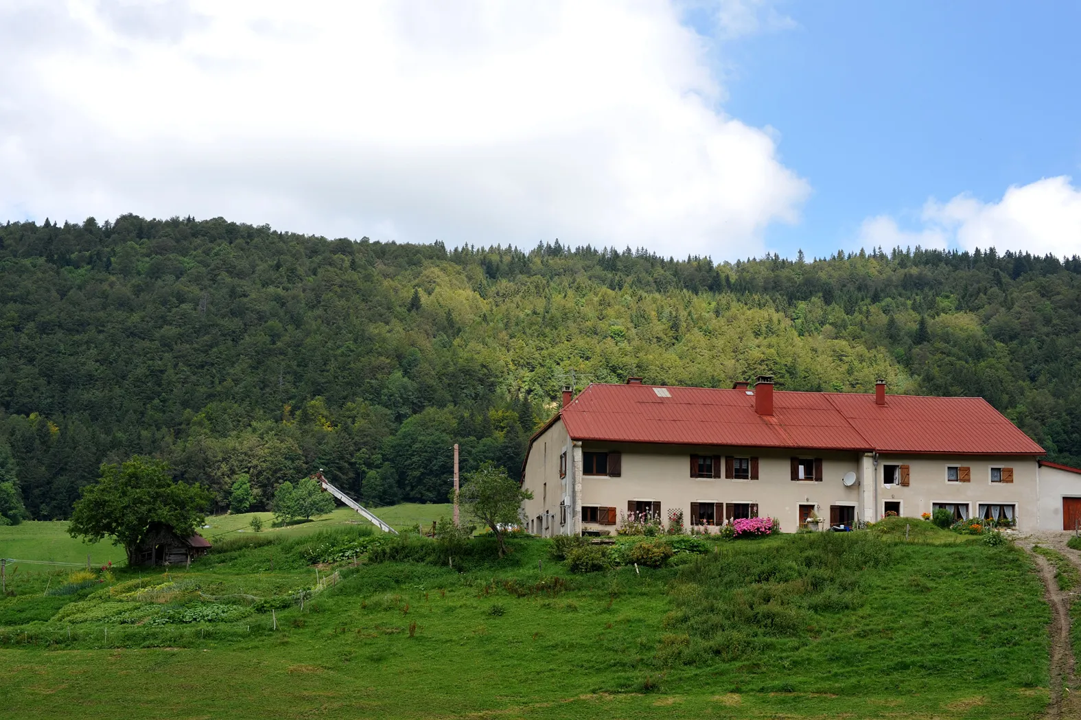 Photo showing: The farm «La petite Bachaudie», Combe de Mijoux; Jura, France.
Domicile of Denis and Alice Poncet, view to northwest. The door of the small storehouse left of the farmhouse used the Poncet's to signal to Michel Hollard if the area is free of enemies.