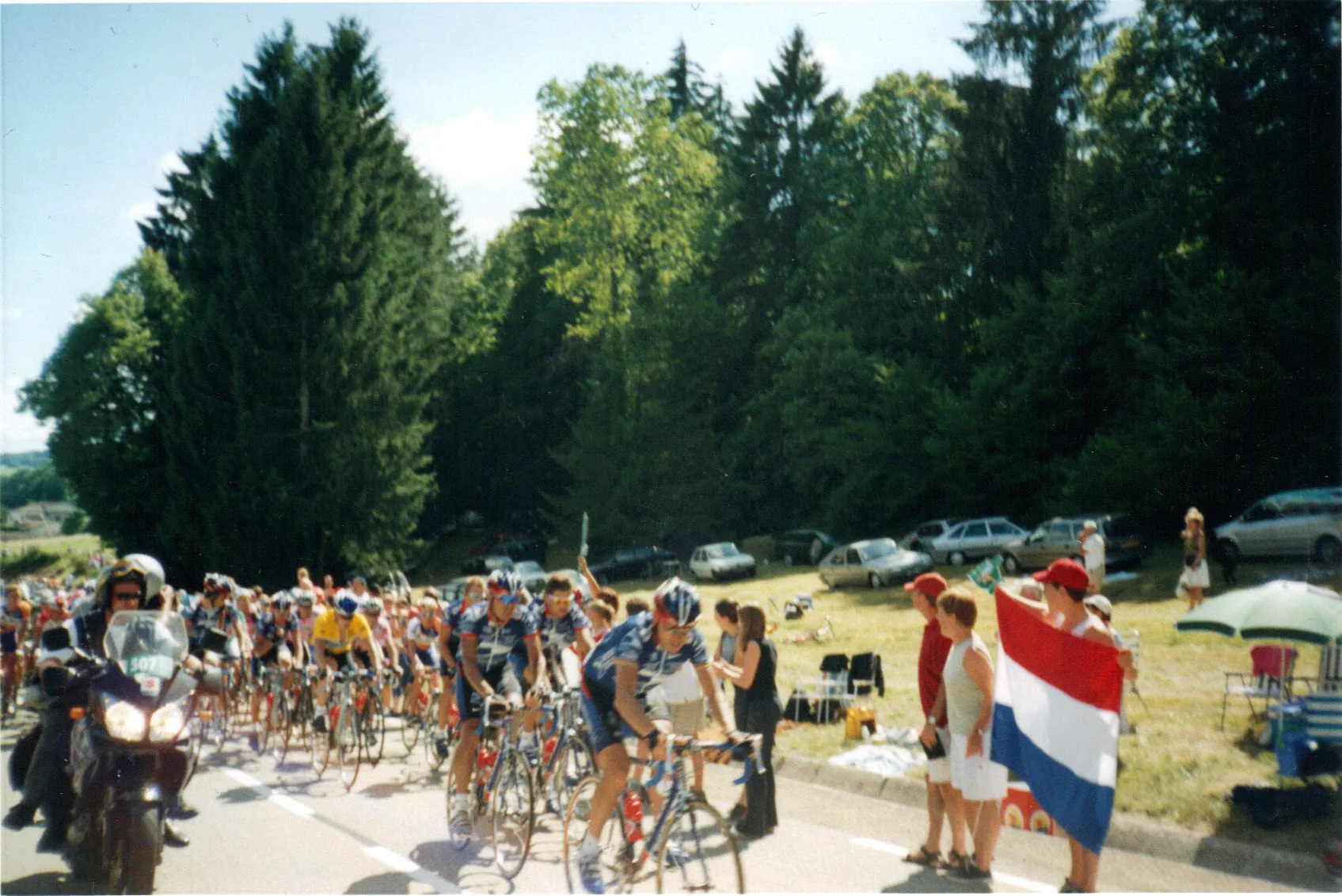Photo showing: Le peloton lors de l'étape 18 du Tour de France 2002 en sortie de Nurieux-Volognat (Ain), dans la montée du col du Berthiand