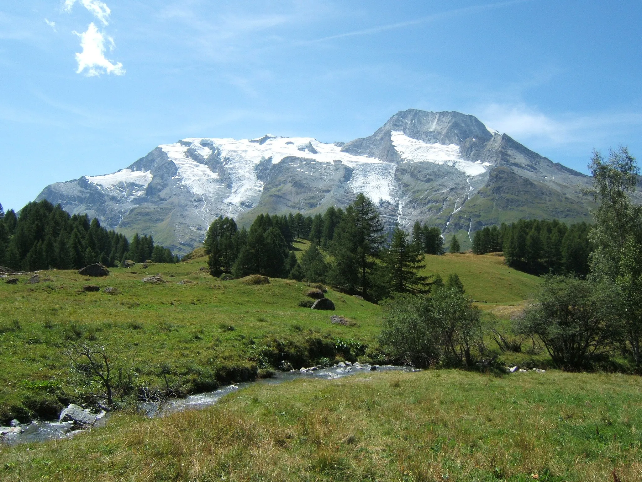 Photo showing: Le hameau du Monal à Sainte-Foy-Tarentaise en Haute-Tarentaise, dans le parc de la Vanoise, en Savoie. En arrière plan, se dresse les faces est du Mont Turia sur la droite du massif et du Mont Pourri au centre (avec la Brèche Puiseux à son pied, côté sud), ainsi que le Dôme de la Sache sur la gauche. Au premier plan, coule paisiblement le ruisseau du Clou.