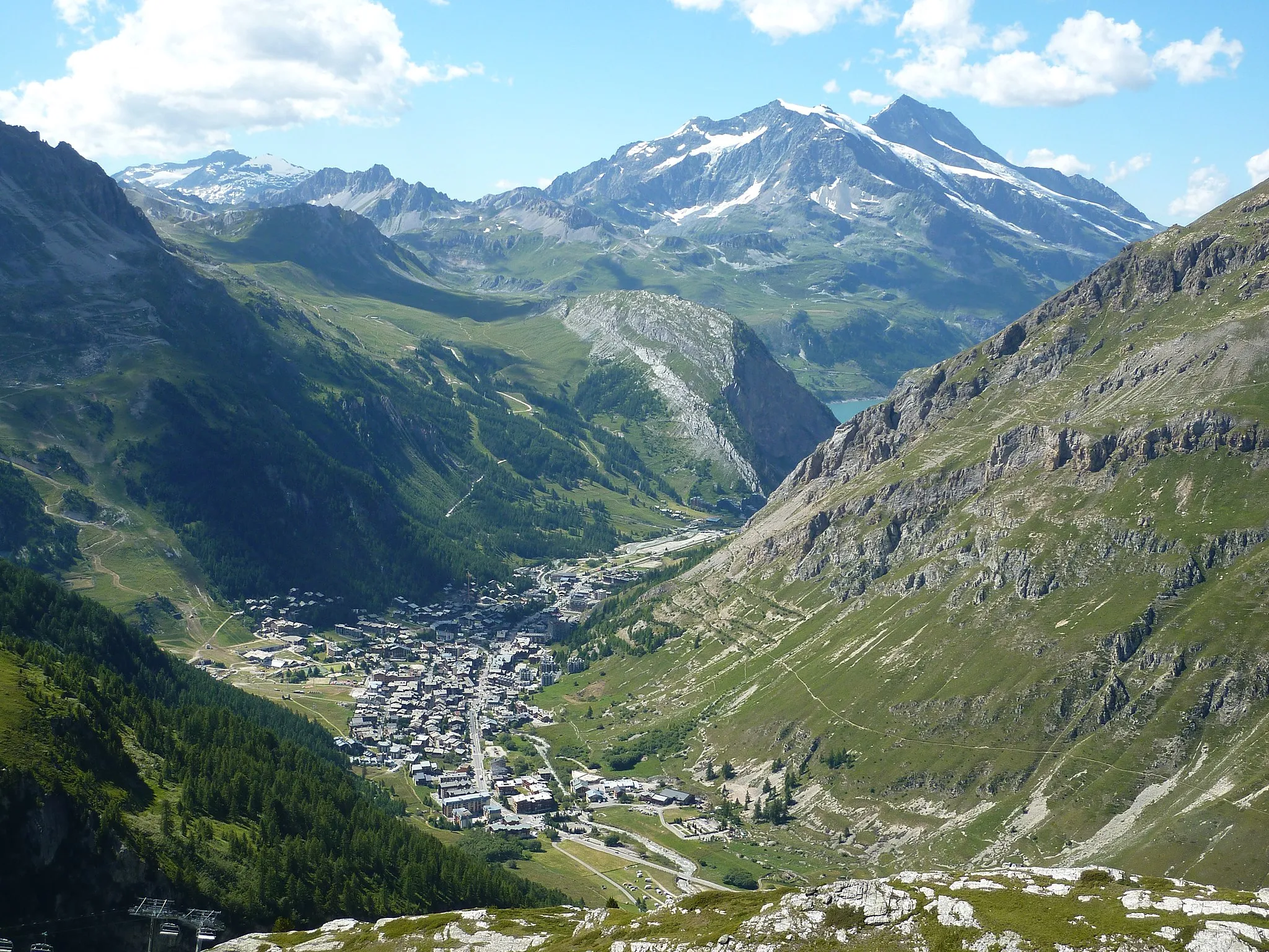Photo showing: Vue d'ensemble de Val d'Isère (73 - FRANCE) avec au fond le lac de Chevril et le mont Pourri (3779 m). Photographie du 31/07/2012 prise dans la descente nord du col de l'Iseran.