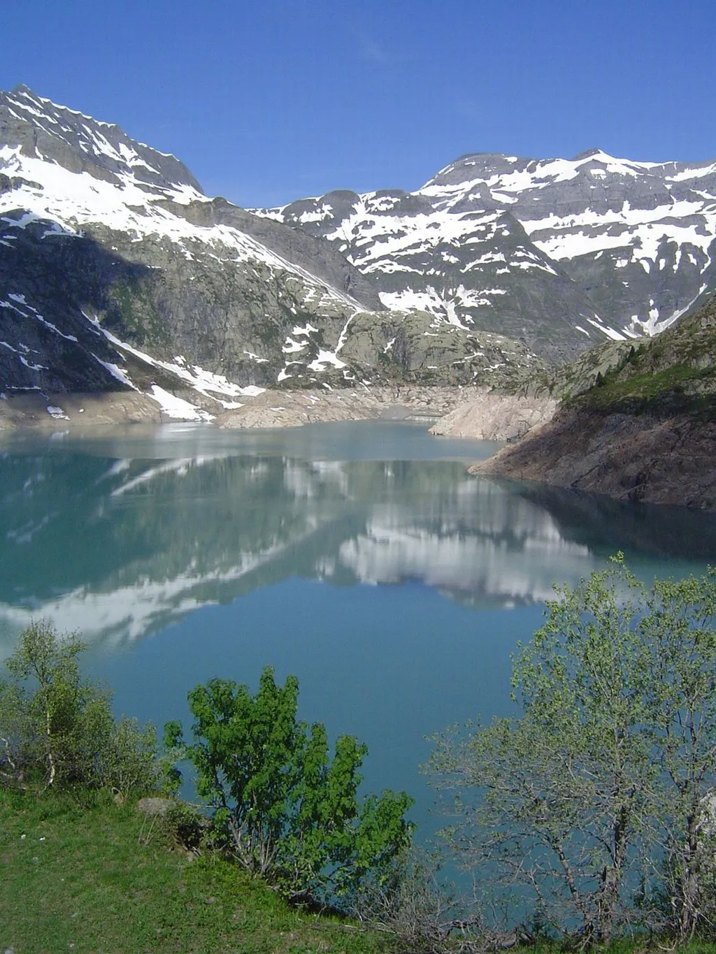 Photo showing: Der Lac d'Emosson, das Ausflugsziel am oberen Ende des "Parc d'Attractions du Châtelard". Ganz im Hintergrund ist die Krone der alten Staumauer "Barberine" zu erkennen, welche in diesem grösseren Stausee liegt und jeweils bei Vollstau unter dem Wasser verschwindet. Aufnahme vom 22.06.2008. Bild: Thomas Brändle, Schweiz