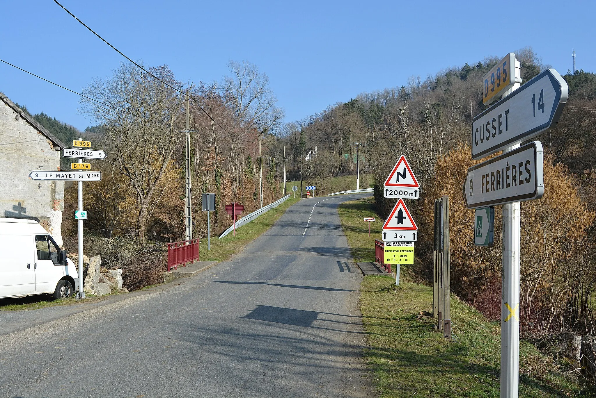 Photo showing: Sortie d'Arronnes par la route départementale 995 en direction de Ferrières-sur-Sichon (Allier, Auvergne-Rhône-Alpes, France), à l'intersection avec la route départementale 176 menant au Mayet-de-Montagne. Début de l'ascension de la côte de Cheval-Rigon, empruntée à plusieurs reprises par le Paris-Nice dont en 2023 (3e catégorie).