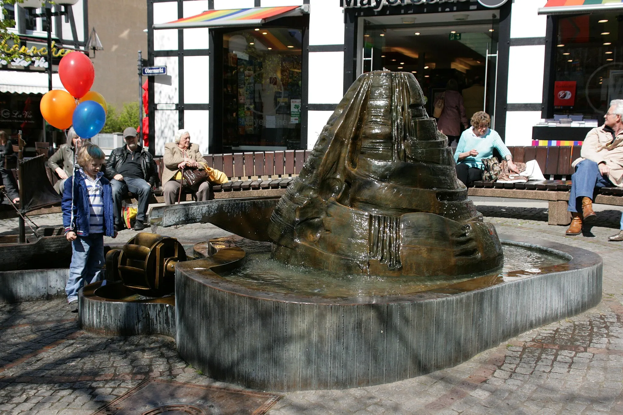 Photo showing: Treidelbrunnen auf dem Obermarkt in Hattingen, dahinter denkmalgeschütztes Fachwerkhaus Kleine Weilstraße 27/Obermarkt 13a (Mayersche Buchhandlung)