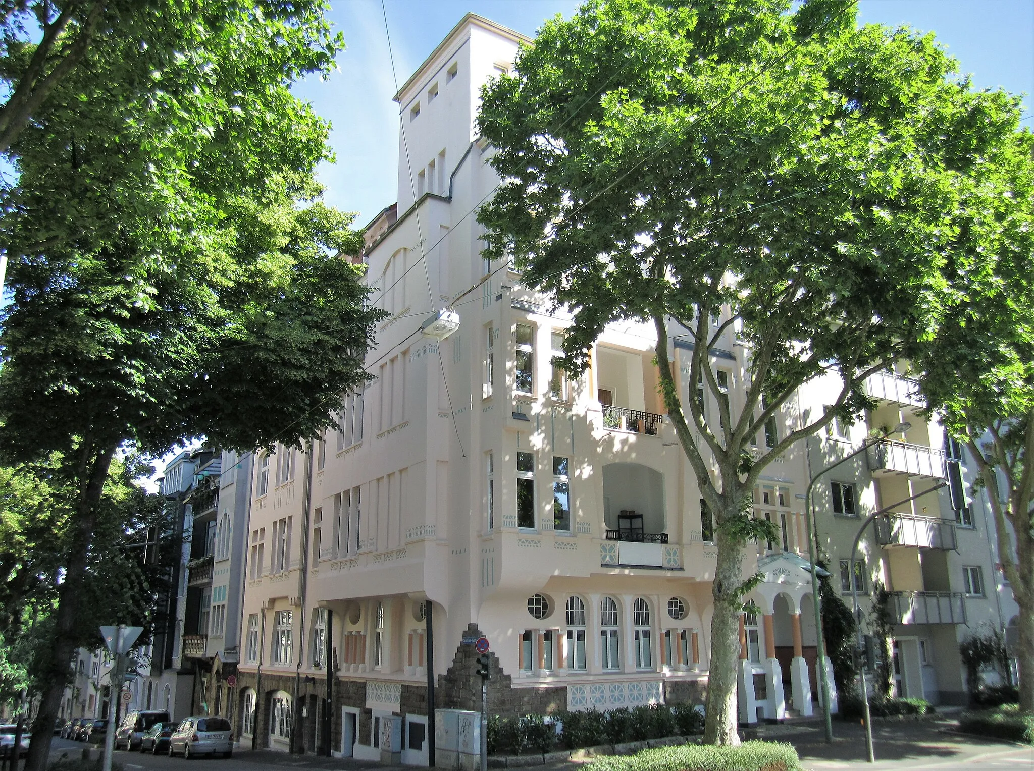 Photo showing: Denkmalgeschütztes Wohnhaus in Hagen-Wehringhausen, Buscheystraße 48 Ecke Christian-Rohlfs-Straße. Vor 1910 von Architekt und Bauunternehmer Josef Fischer errichtet. Das imposante an einer Platanenallee gelegene ehemalige Beamtenhaus weist einen prachtvollen Turmaufbau auf. Zur Buscheystraße gerichtet ist der Balkon im Prachtgiebel in Omega-Form gestaltet, die in der Jugendstilarchitektur variiert Verwendung gefunden hat. Der Eingangsbereich ist ebenso hochherrschaftlich mit Säulen und Dreiecksgiebel inszeniert, mit dem der geometrische Reliefschmuck korrespondiert.