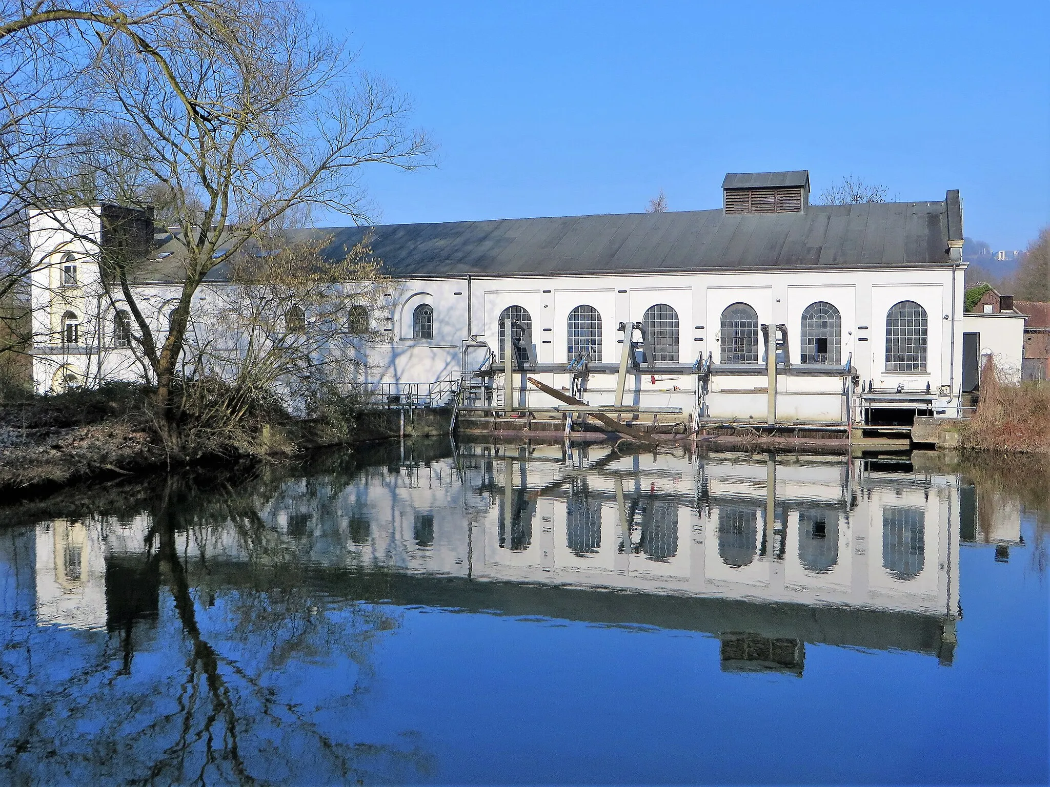 Photo showing: Laufwasserkraftwerk Buschmühle in Hagen-Garenfeld, Ruhrtalstraße. Ehemalige historische denkmalgeschützte Wassermühle. Der Wasserlauf „Kuckucksstrang“ im Vordergrund ist ein seitlicher Altarm der Lenne.