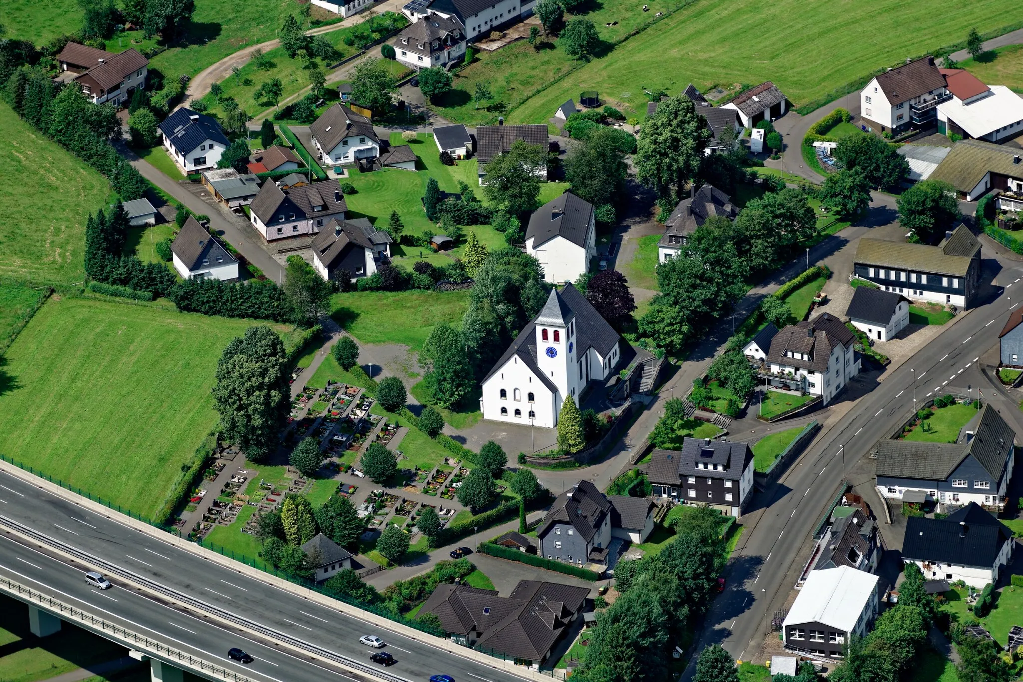 Photo showing: Luftaufnahme: Drolshagener Ortsteil Bleche mit katholischer St.-Josef-Kirche und Friedhof; Bundesautobahn 45; Bundesstraße 54, Nordrhein-Westfalen.