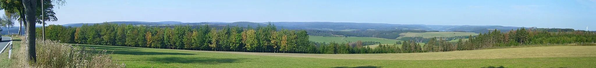 Photo showing: Blick von der B 62 südöstlich von Leimstruth (Balde) auf die Rothaar. Ganz rechts die Windräder nordwestlich von Sassenhausen und nordöstlich von Weidenhausen, etwas weiter links und hinten das Massiv der Ziegenhelle mit Wallershöhe (812,3 m; 20,7 km entfernt, teilverdeckt durch den 587,0 n hohen und 5,5 km entfernten Heßler), Ziegenhelle (816,1 m; 20,7 km) und der vorgelagerten Homburg (721,8 m;15,8 km), davor der Sendemast Großes Hillscheid unmittelbar östlich de:Bad Berleburgs; etwas weiter links sieht man am Fuß der Berge Teile von Raumland, dann den Kahlen Asten (841,9 m; 24,3 km), der nach links optisch unmittelbar in die im Relief unauffällige Kühhuder Rothaar mit dem Albrechtsberg (771,2 m; 17,4 km) und dem Großen Kopf (740,8 m; 12,2 km) übergeht. Die Scharte zur Rüsper Rothaar ist durch die Kilbe (631,5 m; 5,3 km) im Auer Ederbergland rechts der Eder verstellt, links derer sich zunächst der niedrigere Kamm der Rüsper Rothaar und schließlich der auffällige Härdler (756,0 m; 14,4 km) sowie die Hohe Hessel (743,4 m; 12,7 km) anschließen, deren linker Teil durch den Strauch (643,0 m; 5,3 km) verstellt ist. In Höhe des Alleebaums schließlich der Milsenberg (670,3 m; 13,7 km.

– siehe Udeuschle