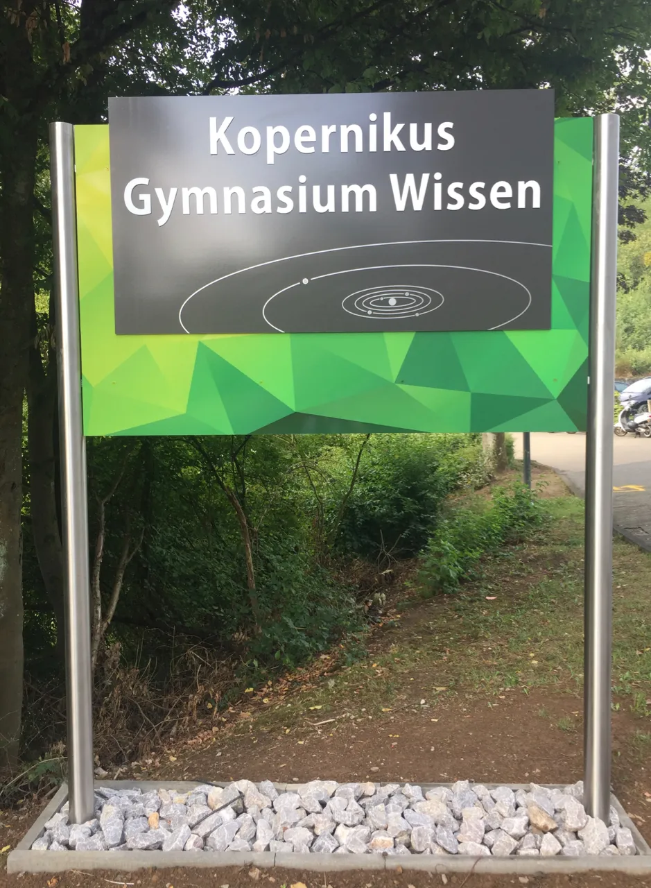 Photo showing: Tafel am Eingang des Kopernikus-Gymnasiums mit dem Schriftzug der Schule an der oberen Auffahrt des Parkplatzes