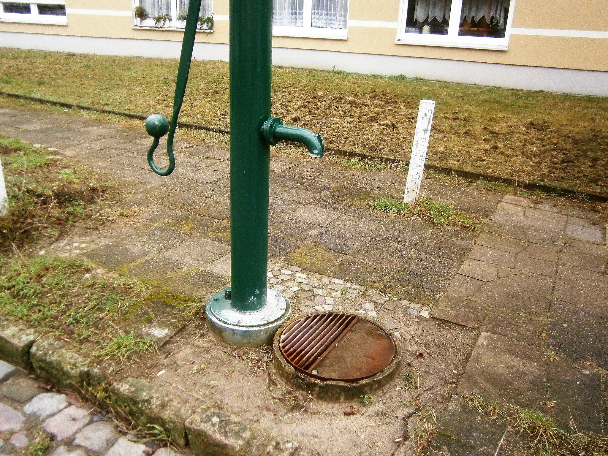 Photo showing: Der Straßenbrunnen23 im Berliner Bezirk Pankow, Ortsteil Wilhelmsruh steht in der Uhlandstraße 20 Meter von deren Südostecke mit der Goethestraße. Der Standort liegt dabei vor dem Neubauhaus mit der Adresse Goethestraße 22 (entsprechend nicht adressierter Uhlandstraße 9). Eigner dieser Pumpe der Notwasserversorgung ist der Bund (Katastrophenschutz).