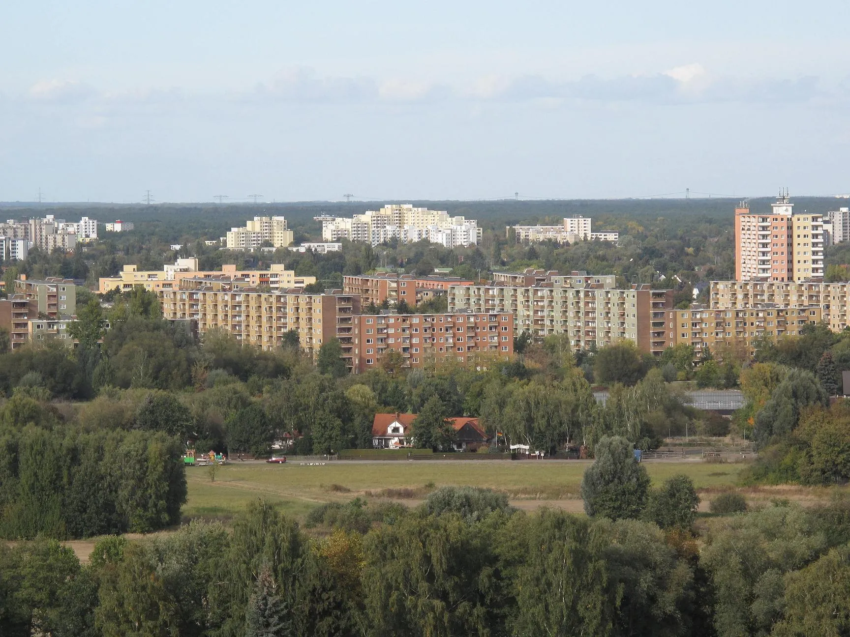 Photo showing: View from the „new“, banked up hill Hahneberg to the Bullengraben-lowland and the Louise-Schröder-Siedlung (settlement) in Staaken. The Bullengraben (german for: bullditch) is a drainage channel to the river Havel in the localities Staaken, Wilhelmstadt and Spandau in the borough Berlin-Spandau, Germany. In 2007 there was opened the green space Bullengraben (german: „Grünzug Bullengraben“) along the 4,5 kilometre long ditch.