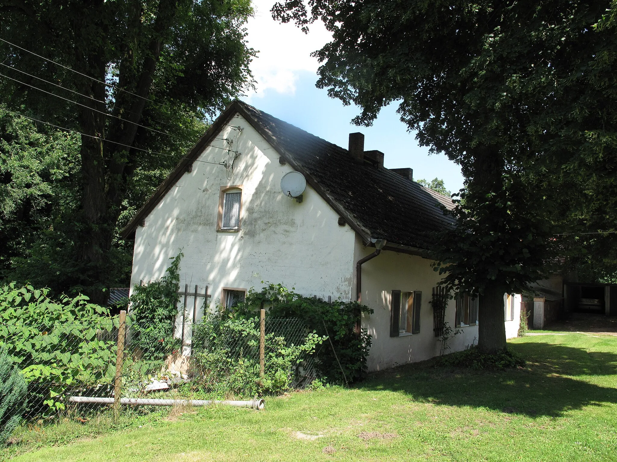Photo showing: Former Grundmühle, one of the three historical watermills of the Blabbergraben, at the southern shore of the Lindenberger See. The mill was pulled down in 1927, its area is still inhabited. The Lindenberger See is a lake in the village Lindenberg, a part (german: Ortsteil) of the municipality Tauche in the District Oder-Spree, Brandenburg, Germany. The lake covers 6 hectare. The long-drawn groove lake is, seen from the north, the second water of a five-part chain of lakes, which is connected by the Blabbergraben. The Blabbergraben drains the lakes to the south into the river Spree.