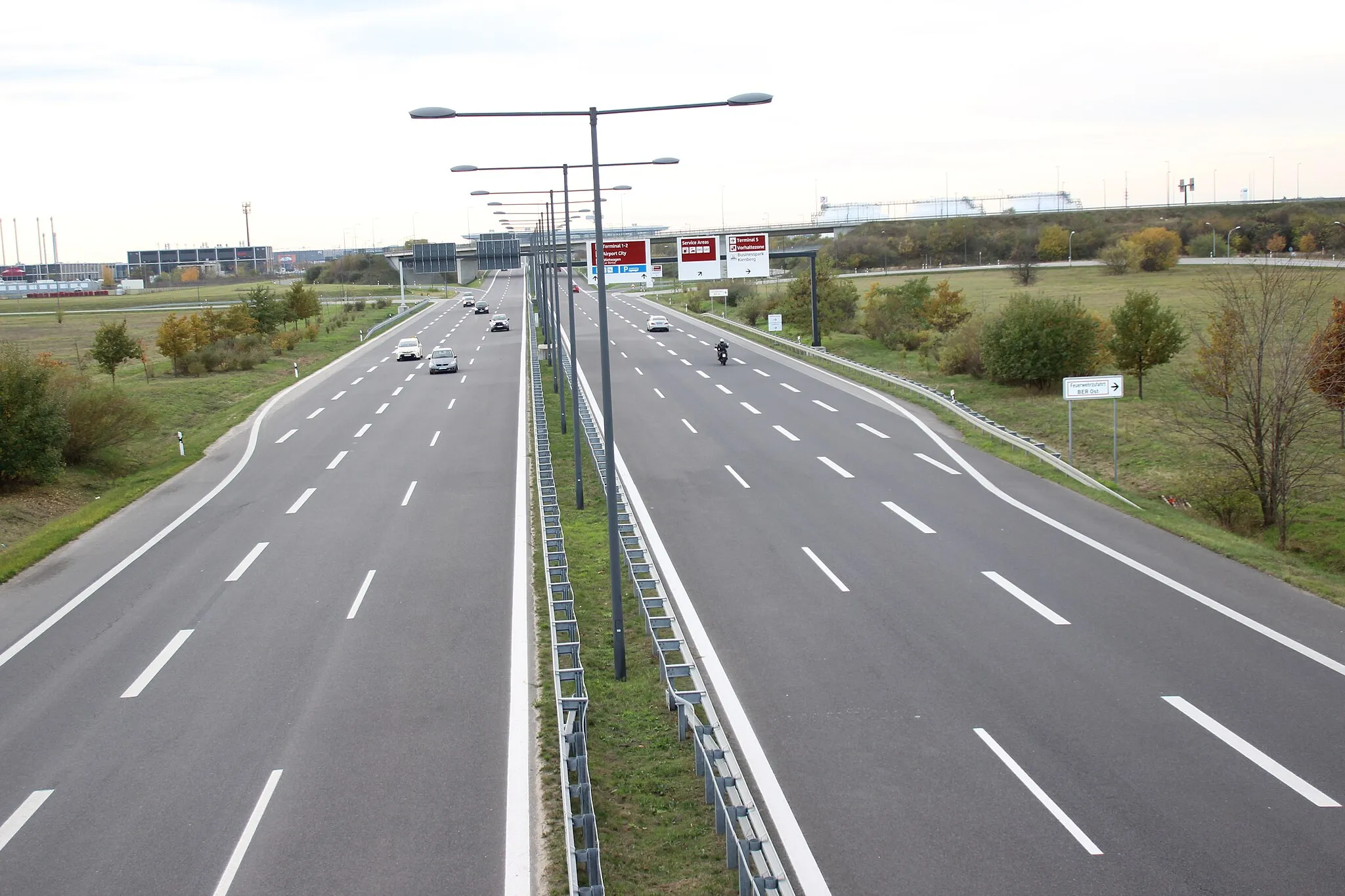 Photo showing: 2010 eröffnete Flughafen-Anschlussstelle mit Blick in Richtung Flughafen BER Terminal 1 und 2. Blick von einer unbenannten Straße, die die Berliner Chaussee mit der Hugo-Eckener-Allee verbindet und bereits zu Waltersdorf gehört.