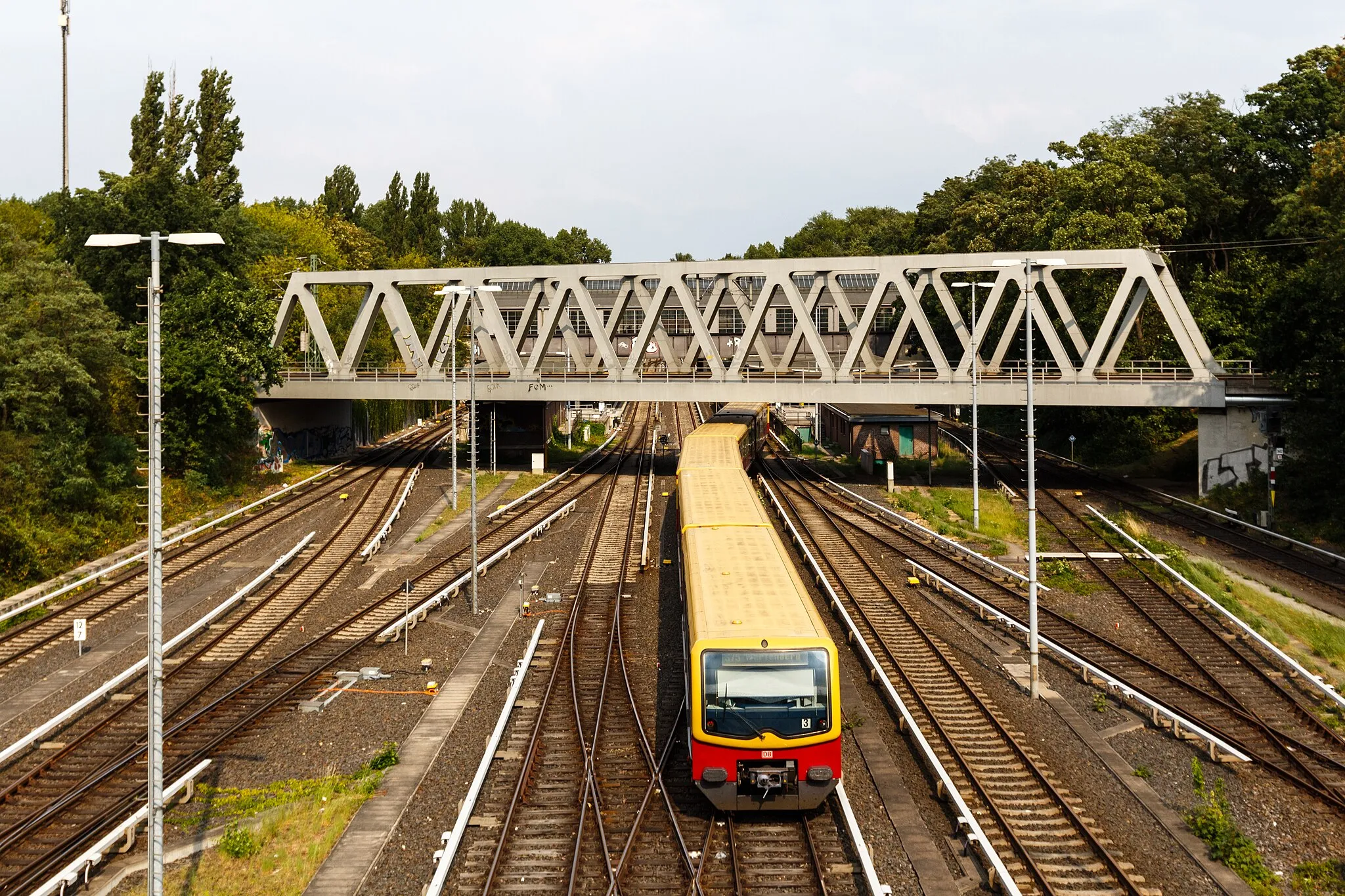 Photo showing: Blick von der Halenseestraßenbrücke nach Osten. Westlich des Bahnhofs Berlin-Westkreuz teilen sich die S-Bahnstrecken in die Spandauer Vorortbahn und die Strecke nach Wannsee und Potsdam auf. Im Hintergrund die Brücke der nördlichen Verbindungskurve zwischen Ringbahn und Fernbahnstrecke nach Potsdam.