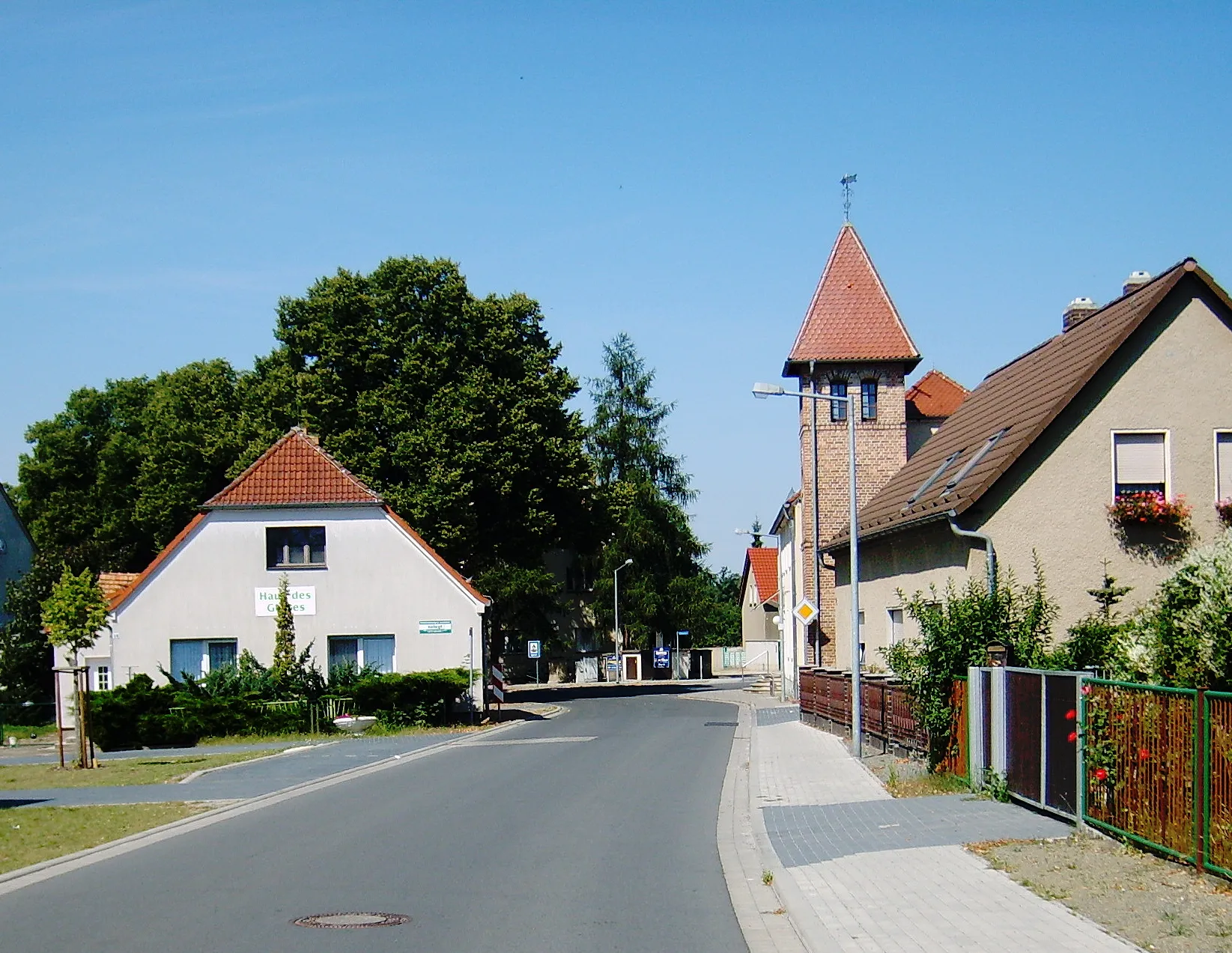 Photo showing: Das Dorf Grünewalde bei Lauchhammer.
Lindenallee bei Hausnr. 4 (nicht im Bild) westwärts: rechts Lindenallee 2, dahinter Schulplatz 2 mit Heimatmuseum und Glockkenturm; links Schulplatz 10 (Haus des Gastes / Pension Linnemann)