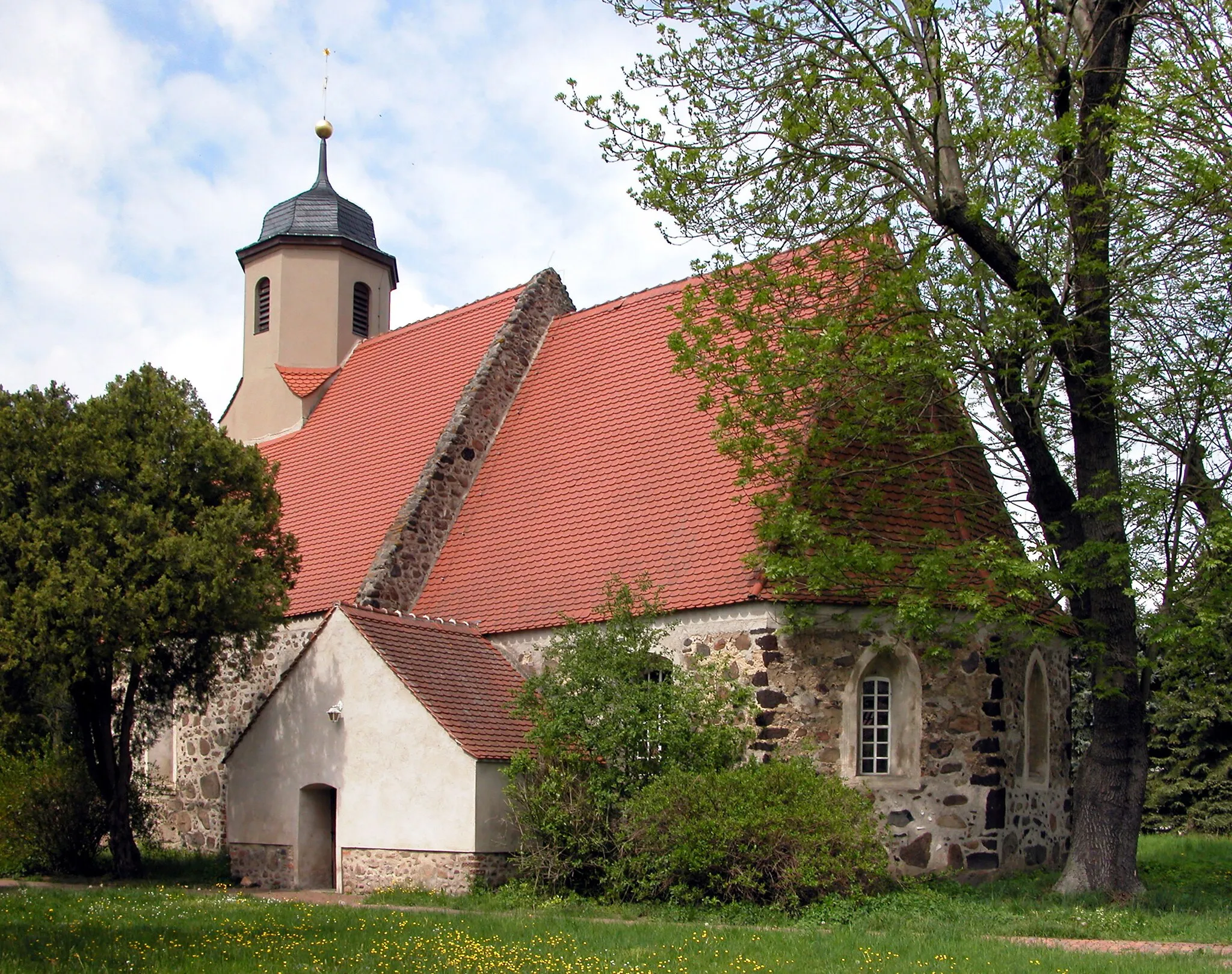 Photo showing: 08.05.2015    03249   Zeckerin (Sonnewalde), Dorfstraße 34A: Spätgotische Feldsteinkirche (GMP: 51.711797,13.632377) aus kurzem Schiff und eingezogenem, dreiseitig geschlossenem Chor. In ihm haben sich zwei gotische Spitzbogenfenster erhalten. Auf der Südseite gibt es zwei gestufte Backsteinportale: Das zum Schiff ist zugesetzt, das zum Chor liegt hinter der barocken Südvorhalle und weist auf seinem Türblatt spätgotische Beschläge auf.                                                                                                                                                                                              [DSCN5312JPG]20150508115DR.JPG(c)Blobelt