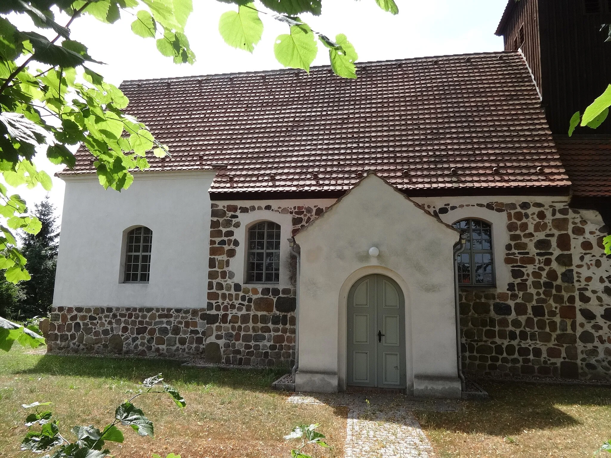 Photo showing: Die Dorfkirche in Schönefeld ist eine Feldsteinkirche aus dem 13. Jahrhundert in Beelitz im Landkreis Potsdam-Mittelmark in Brandenburg. Sie wurde barock überformt und um einen Westturm ergänzt. Im Innern befinden sich ein Kanzelaltar aus dem Jahr 1715 sowie Reste mittelalterlicher Wandmalereien.
