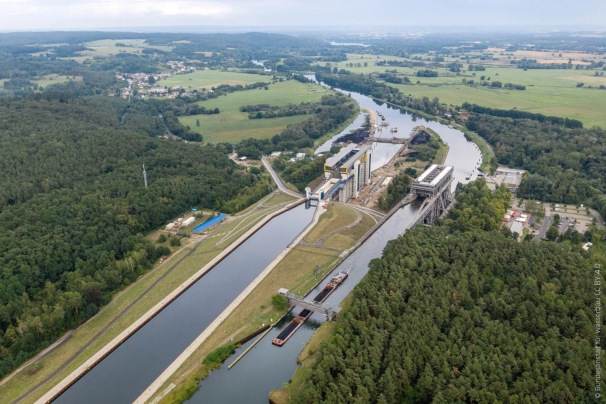 Photo showing: Blick Richtung Osten auf beide Hebewerke und die jeweiligen Vorhäfen. Beim oberen Vorhafen des alten Hebewerks rechts ist in 289 m Entfernung vom Hebewerk das 30 m breite Sicherheitstor (Schiff liegt genau darunter) zu erkennen. Beim neuen Hebewerk ist das Sicherheitstor nur 80 m davon entfernt, das heißt fast direkt hinter der nur 65,50 m langen Kanalbrücke.