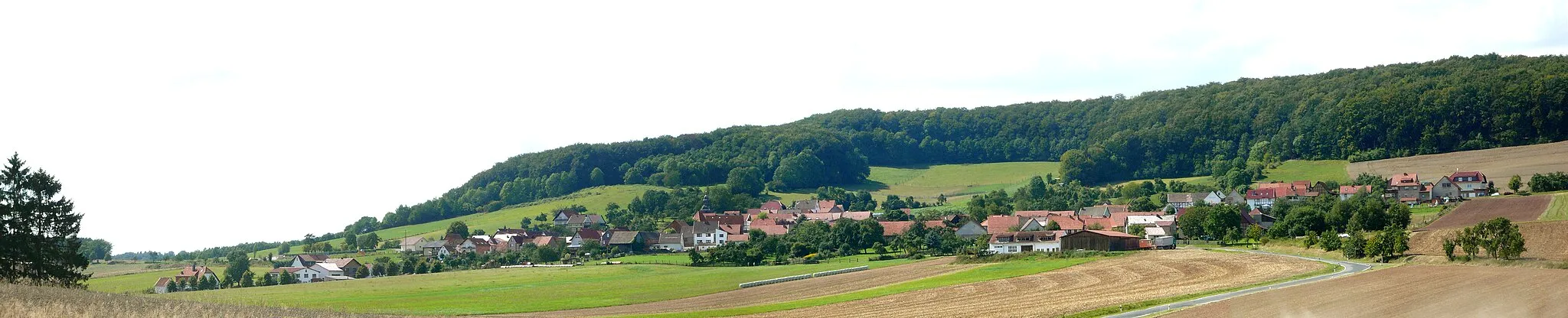 Photo showing: Blick von Osten auf Rohrberg, Landkreis Eichsfeld, Thüringen. Hinten der Mädchenberg (Bildmitte) und der Rohrberg (rechts). Panoramaaufnahme