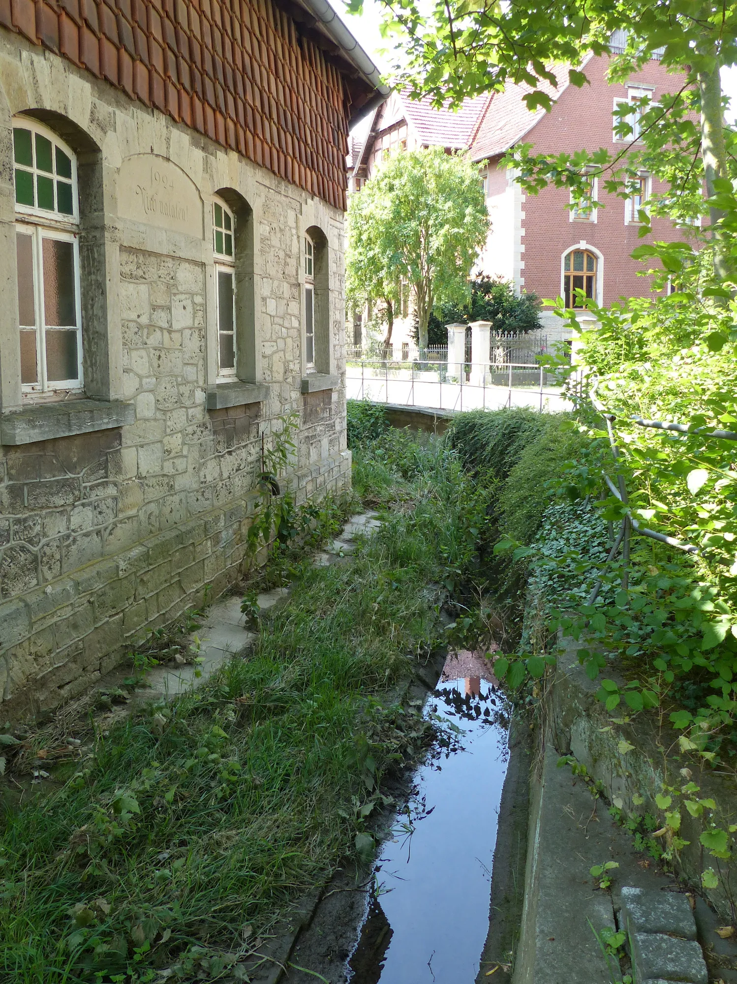 Photo showing: Krumme Beeke (Hachumer Bach) beim Beekendamm in Dettum, stromabwärts. Links Inschrift: "1924 Nich nalaten"