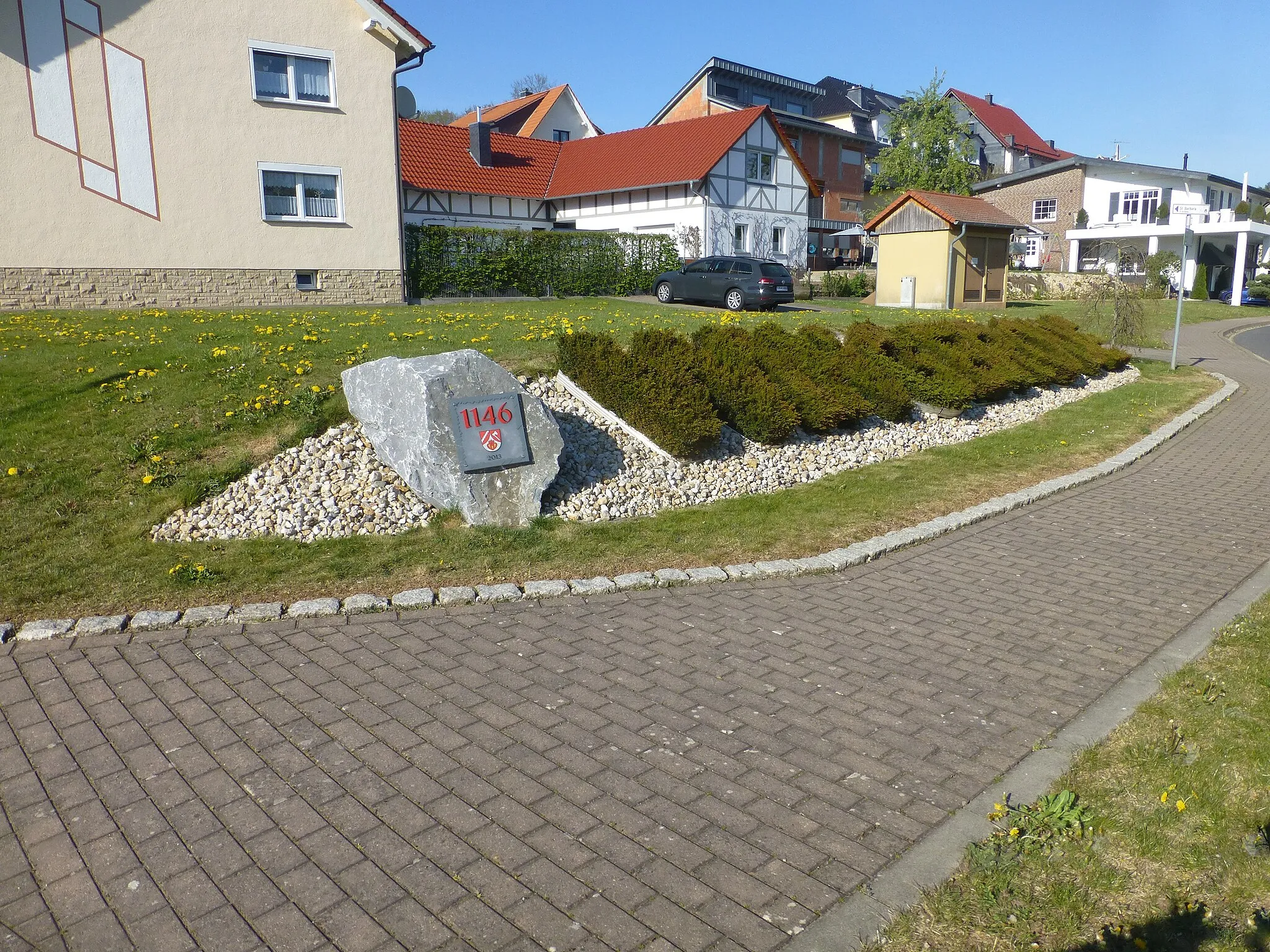 Photo showing: Stein mit Plakette zur Ersterwähnung 1146 und Hecke mit Schriftzug "Wingerode"
