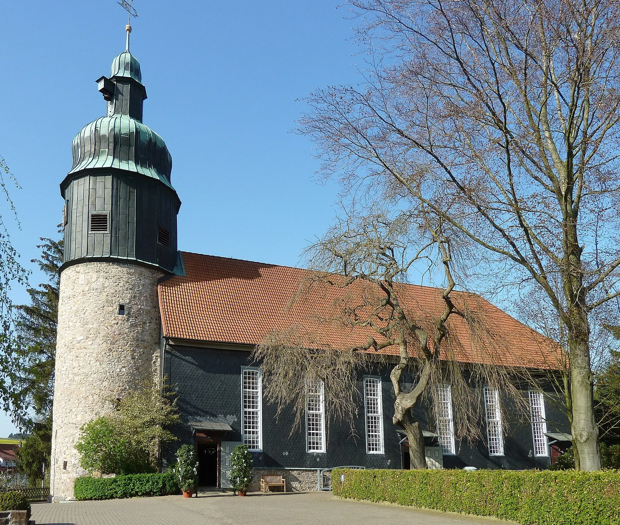 Photo showing: Ev.-luth. Kirche St. Pankratius in Hattorf am Harz, Landkreis Osterode, Niedersachsen. Turm als Wehrturm einer mittelalterlichen Wehr- und Fliehburg im 10./11. Jahrhundert errichtet, Kirchenschiff in Fachwerkbauweise (mit Schieferbehang) 1756 angebaut (Quelle: Informationstafel an der Kirche)