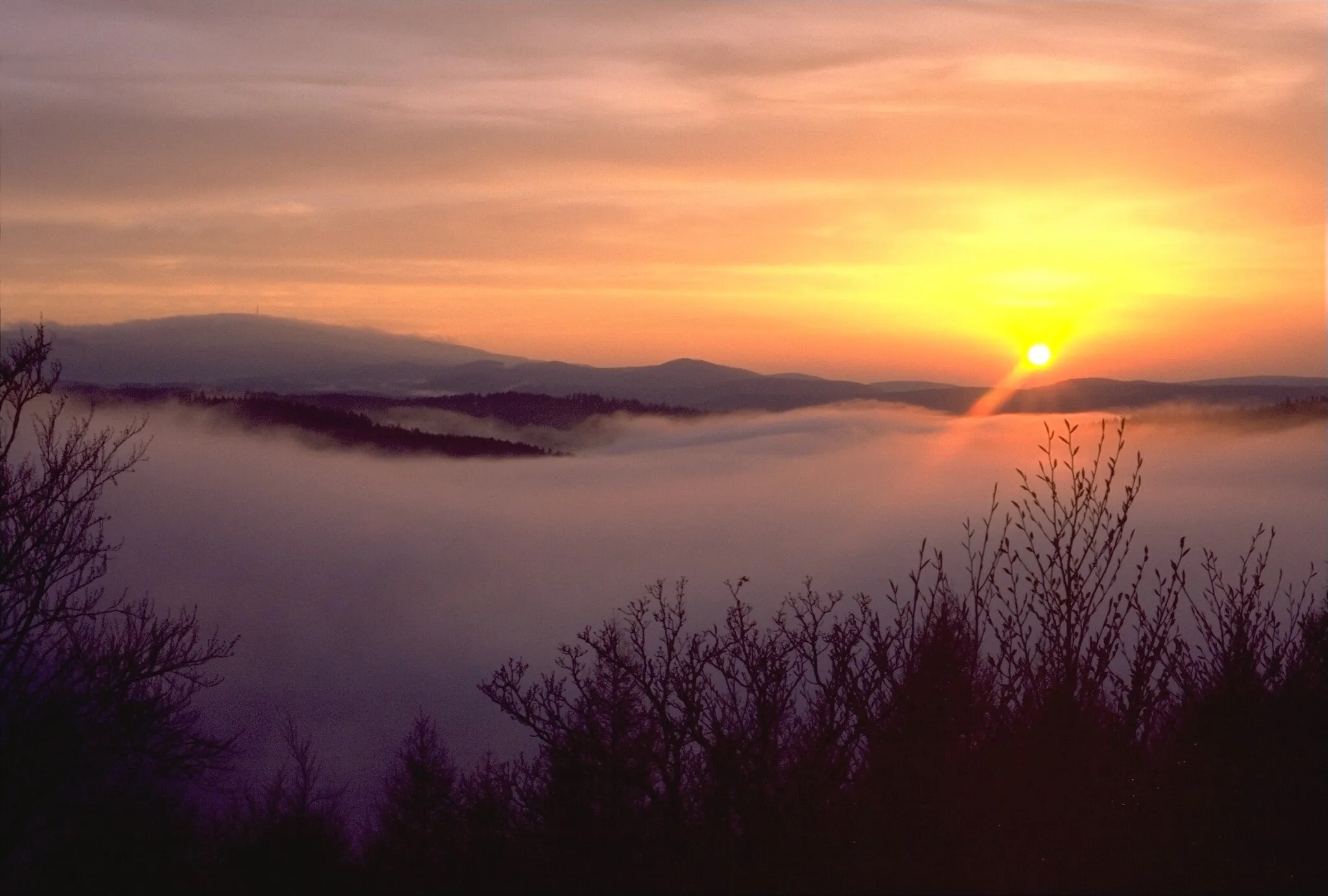 Photo showing: View to Brocken from Scharfenstein, "Kaltes Tal" covered with fog, sun set, Harz, Germany
