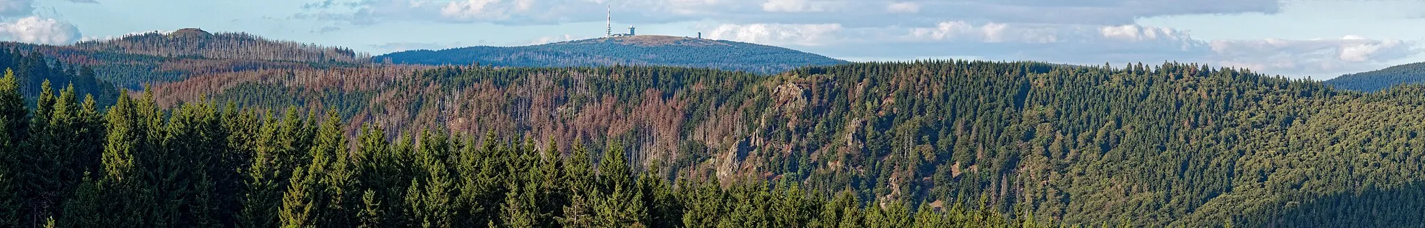 Photo showing: Panorama von Achtermann (links) und Brocken (Bildmitte) aufgenommen von der Jordanshöhe. Im Vordergrund rechts neben dem Brocken die Hahnenkleeklippen.