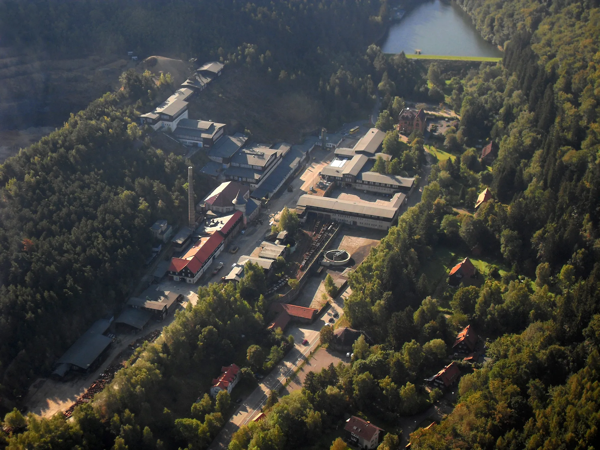 Photo showing: Luftbild des Erzbergwerkes Rammelsberg mit den Verwaltungsgebäuden, Erzaufbereitung und Werkstätten. Am oberen Bildrand ist der Herzberger Teich zu erkennen.