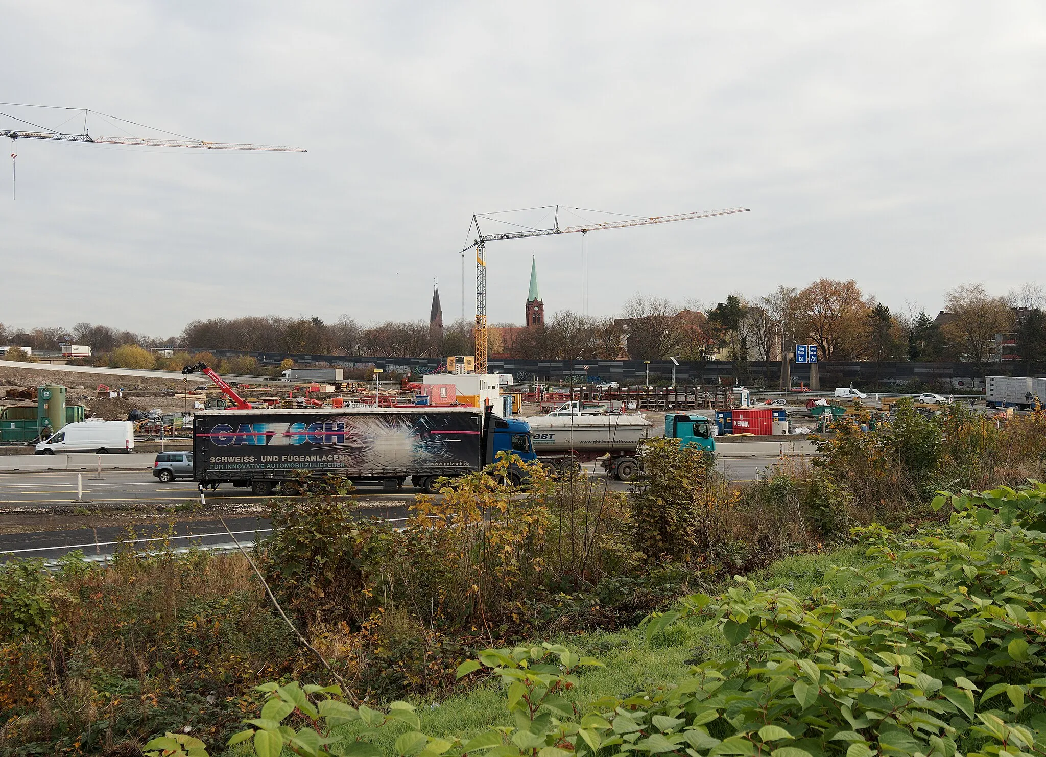 Photo showing: Herne, Umbau des Autobahnkreuzes Herne, Ansicht von Süden. Im Hintergrund die Doppeltürme von de:St. Marien (Herne-Baukau) und der Turm der ev. Matthäuskirche