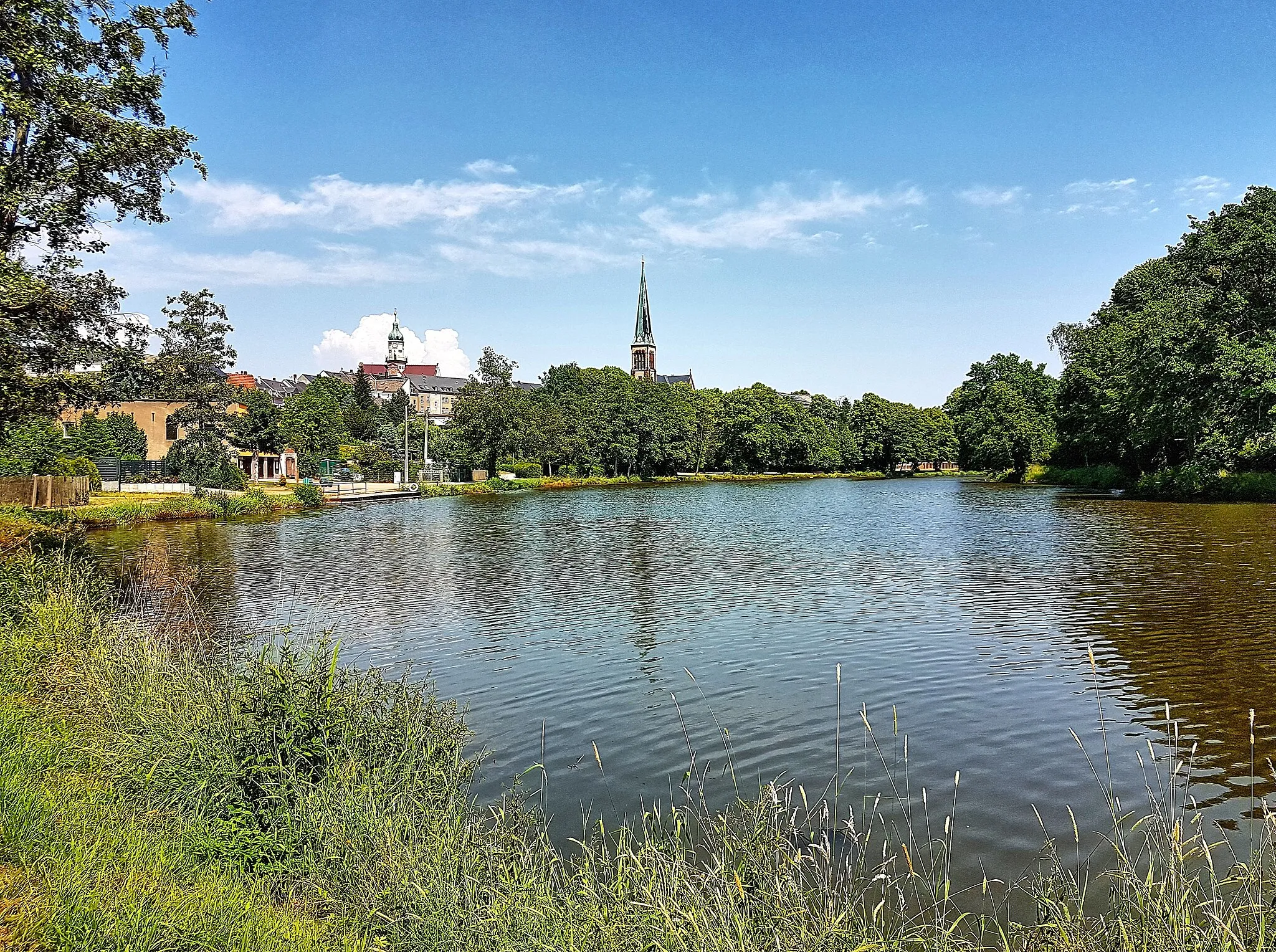 Photo showing: Geringswalde/Saxony/Germany: View over the large pond "Großteich" to the city center with city hall and Martin Luther Church from the west, June 2021 - Location: North bank of the large pond;