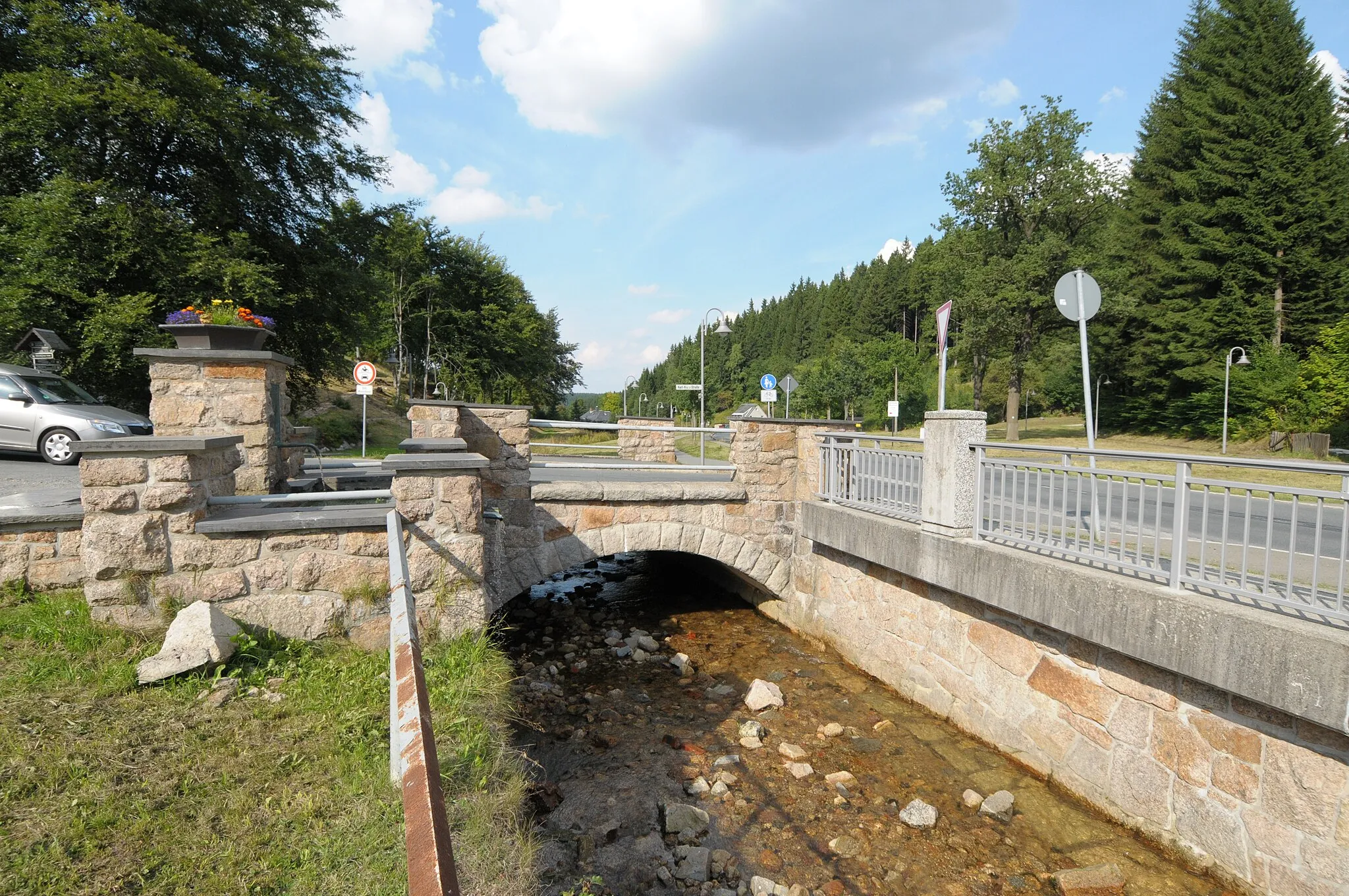 Photo showing: Tannenbergsthal, Brunnen und Straßenbrücke an der Einmündung Klingenthaler Str. / Karl-Marx-Str. (Vogtlandkreis, Sachsen, Deutschland)