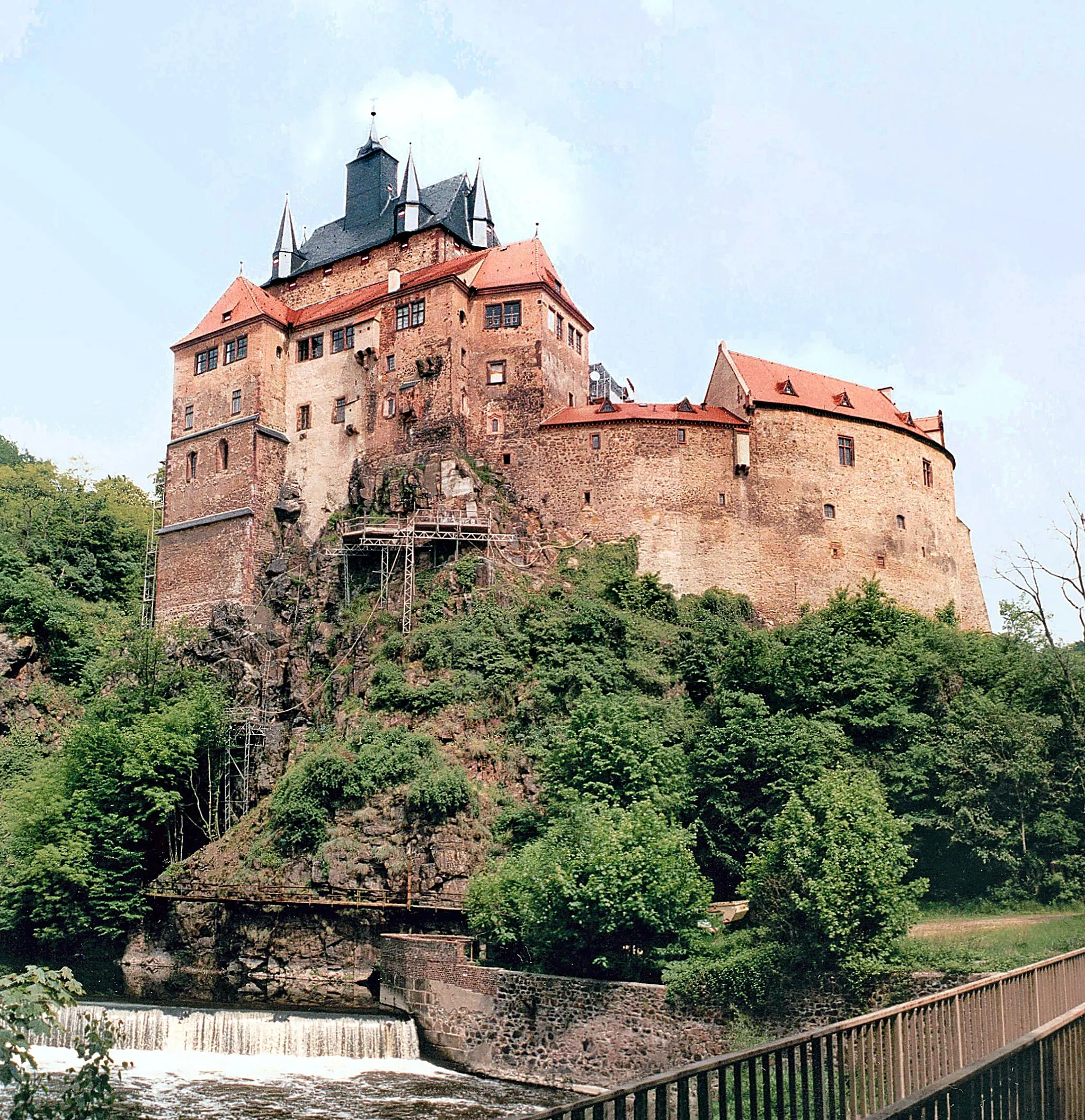 Photo showing: 20.05.2002  09648  Kriebstein: Burg Kriebstein (GMP: 51.042428,13.017510). Die schönste Ritterburg Sachsens. 1384 erhielt Ritter Dietrich von Beerwalde die Genehmigung, "den Krywensteyen czu buwen". Höhepunkte sind der 1384 errichtete monumentale Wohnturm, die Burgkapelle mit Wandmalereien von 1410, das Kriebsteinzimmer sowie die Interieurräume der Familie von Arnim. Das mit Turmspitzen übersäte Dach wurde 1399 aufgerichtet. Spätestens 1407 war die Burg vollendet. 1465 gelangte die Burg an den kursächsischen Obermarschall Hugold von Schleinitz, der in Kriebstein umfangreiche Bauarbeiten durchführen ließ. Die Eigentümer wechselten oft. Die letzten Rittergutsbesitzer waren Erik (1873-1945) und Allard von Arnim (1901-1945). In der Burg wurde nach der Bodenreform das Museum des Kreises Hainichen eingerichtet. 1993 ging die Burganlage in den Besitz des Freistaates Sachsen über. Sicht aus dem Tal der Zschopau.                                                                                     [F20020518A]20020520100MAR.JPG(c)Blobelt