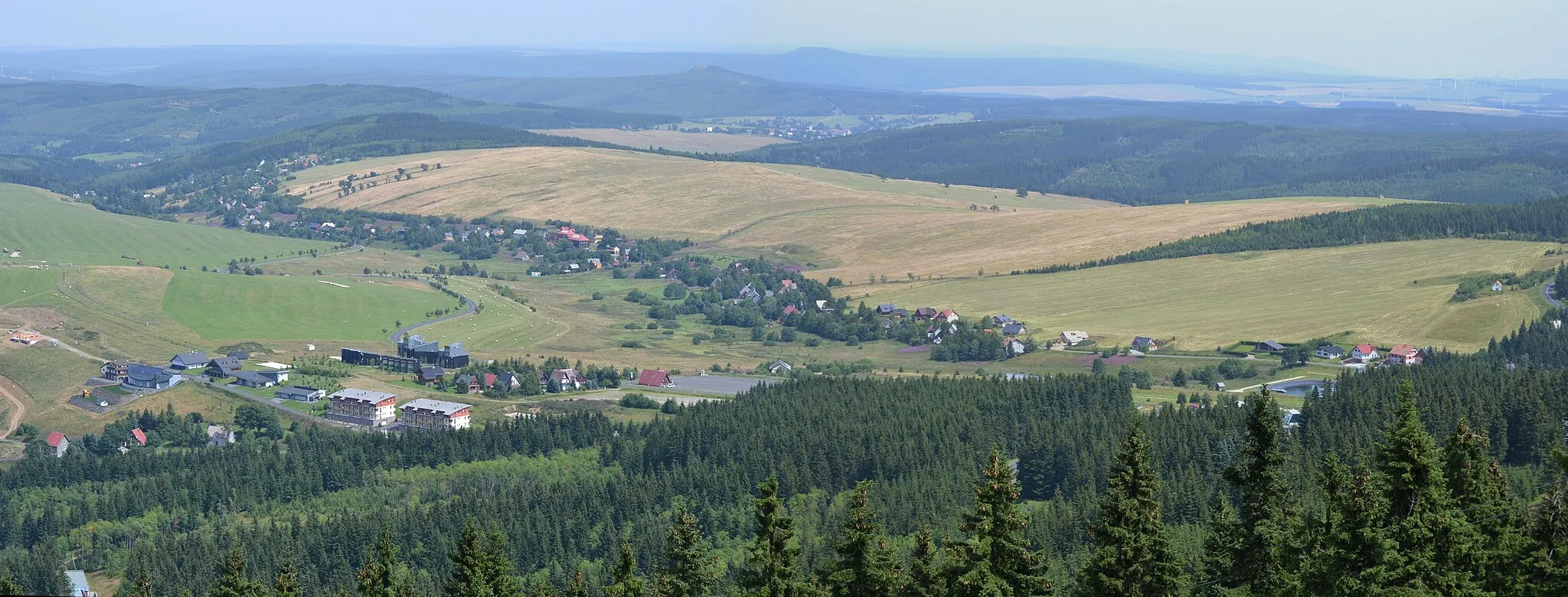Photo showing: Blick von der Plattform des Aussichtsturms auf dem Klínovec nach Nordost auf Háj u Loučné. Dahinter Kovářská mit dem Velký Špičák und am Horizont in Bildmitte der Gipfel des Jelení hora.