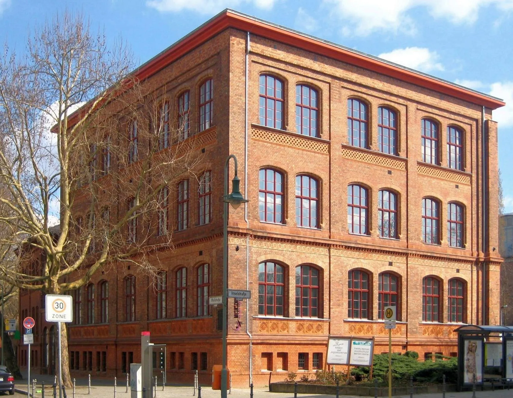 Photo showing: The former Köllnisches Gymnasium (=secondary school) at Wallstraße 42-48, built 1865 by Adolf Gerstenberg, as seen from the corner of Wallstraße and Inselstraße. It used to be a school building with three wings along Inselstraße. After destruction in WWII, only the northern wing along Wallstraße as well as the principal's building, added in 1868 on the same street, are preserved. The buildings are used today by the Music School Fanny Hensel. They have been desiganted as a historic landmark.