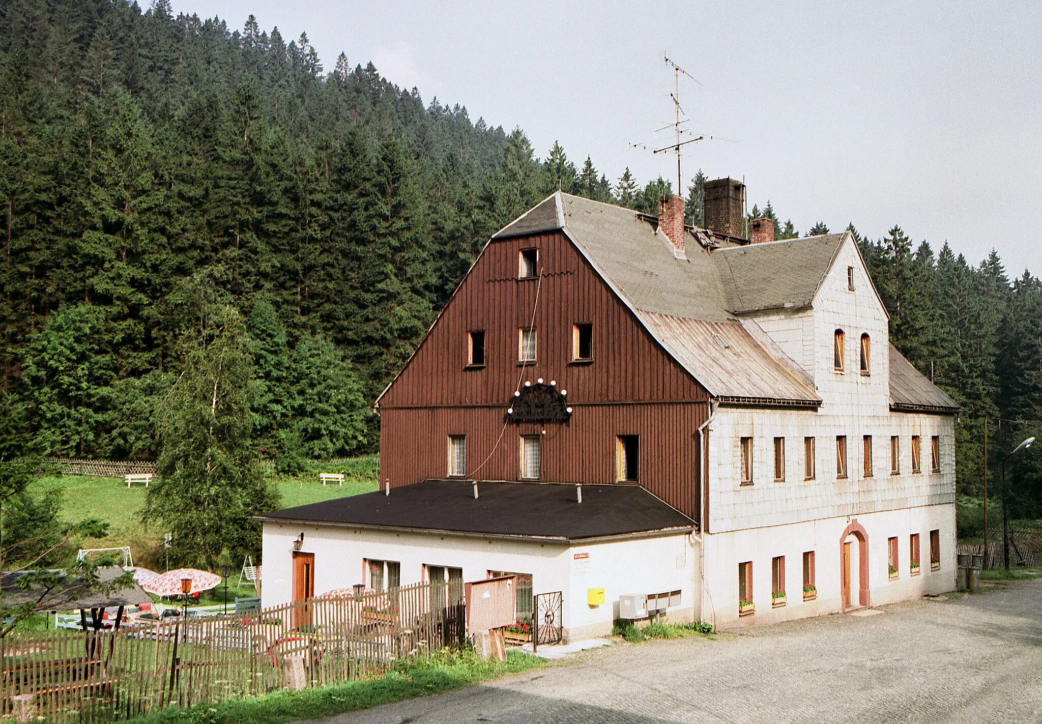 Photo showing: 14.08.1986  DDR 9401  [08309]  Oberwildenthal (Wildenthal, Stadt Eibenstock): Ferienheim des VEB Textilmaschinenbau Aue (Textima Aue), Alte Zollhäuser 4 (GMP: 50.433960,12.64495). Das Gebäude, ehemals der traditionelle Gasthof Geyer, wird 2010 nach Leerstand abgerissen.                                                                  [R19860808B07.TIF]19860814011NR.JPG(c)Blobelt