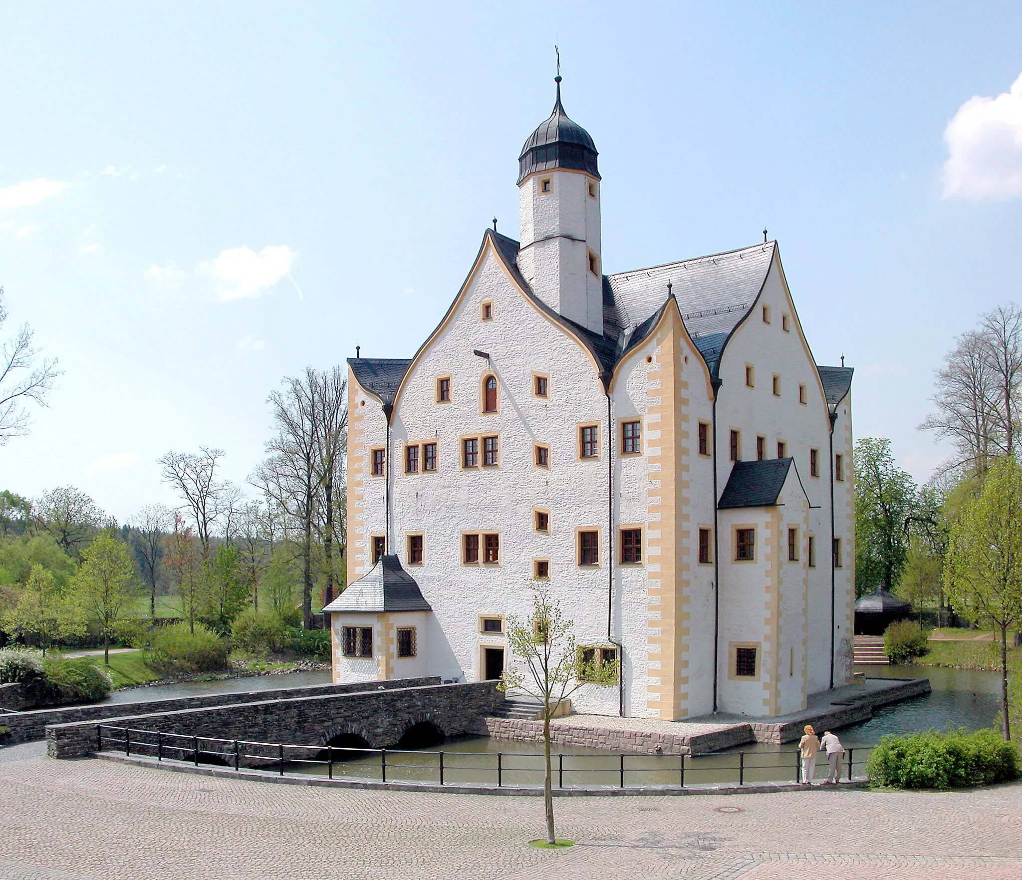 Photo showing: 07.05.2006   09123  Klaffenbach (Chemnitz), Wasserschloßweg 6: Wasserschloß Klaffenbach (GMP: 50.769007,12.888813). Das Renaissanceschloß des einstigen Ritterguts Neukirchen wurde früher auch Hünerkopfs Haus genannt. Schloß und Rittergutshof wurden in der Mitte des 16. Jahrhunderts erbaut, nachdem der Annaberger Münzmeister Wolf Hünerkopf 1543 die einstmals dem Chemnitzer Kloster gehörenden Dörfer Neukirchen, Klaffenbach und Burkhardtsdorf gekauft hatte. Er gründete mit kurfürstlicher Bewilligung das Rittergut Neukirchen. Nach einigen Besitzerwechseln erwarb 1934 die Gemeinde Klaffenbach das verschuldete Schloß. Ab 1935 vom Reichsarbeitsdienst genutzt. Ab 1947 war es Mädchenheim des Jugenamtes und von 1949 bis 1990 Jugendwerkhof für 14 bis 18 jährige Mädchen. Von 1992 bis 1997 wurde das Schloß saniert. Der zugeschüttete Wassergraben wurde 1992 bis 1994 wieder freigelegt. Schloß Klaffenbach hat ein sonst nirgends bekanntes kreuzförmig durchdrungenes Kielbogendach.                                                                     [DSCN9915-9916.TIF]20060507020MDR.JPG(c)Blobelt