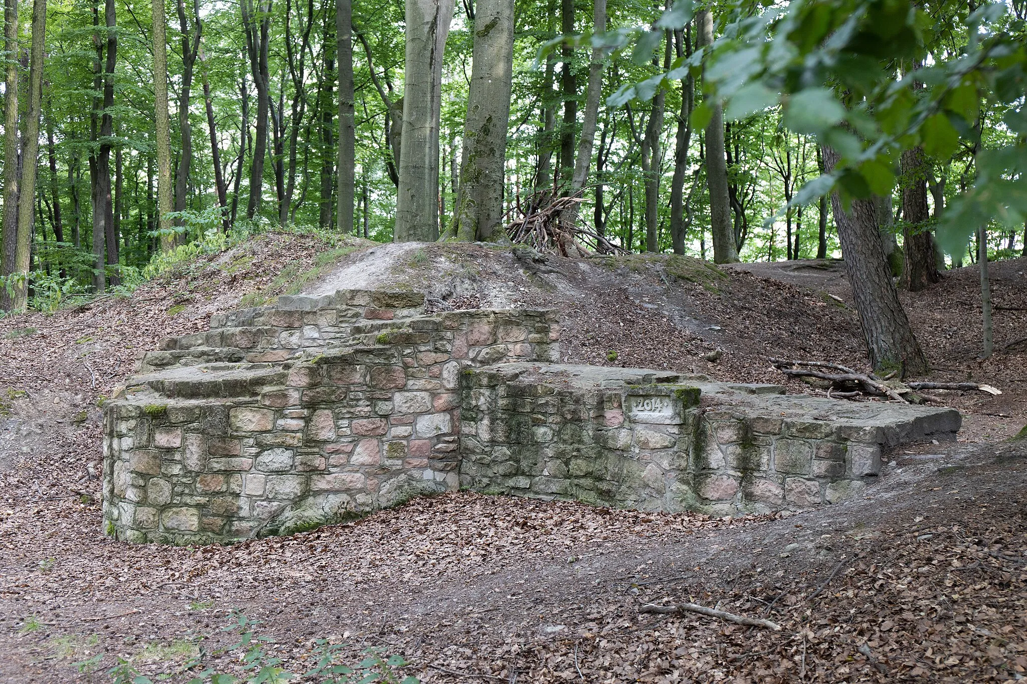 Photo showing: Reconstructed excavation remains (two separate wall sections) and circular rampart of the former castle on the Klosterberg near Rottenberg, Germany.