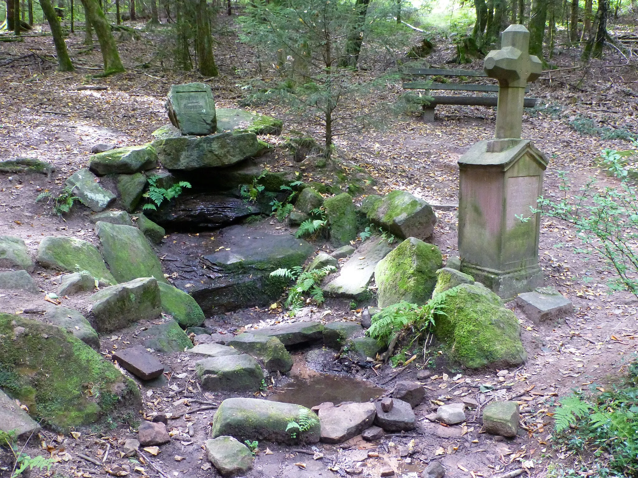 Photo showing: Siegfriedbrunnen südöstlich von Gras-Ellenbach; rechts ein Steinkreuz als Gedenkstein mit Inschrift